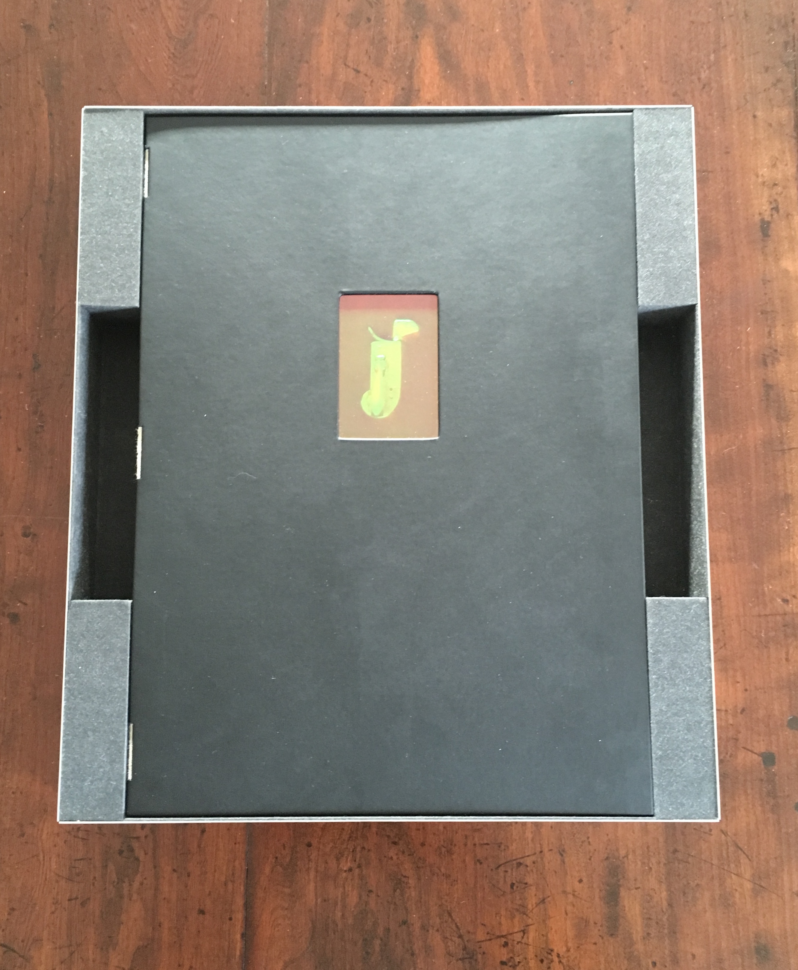 Top of case removed to show book with embedded hologram on cover