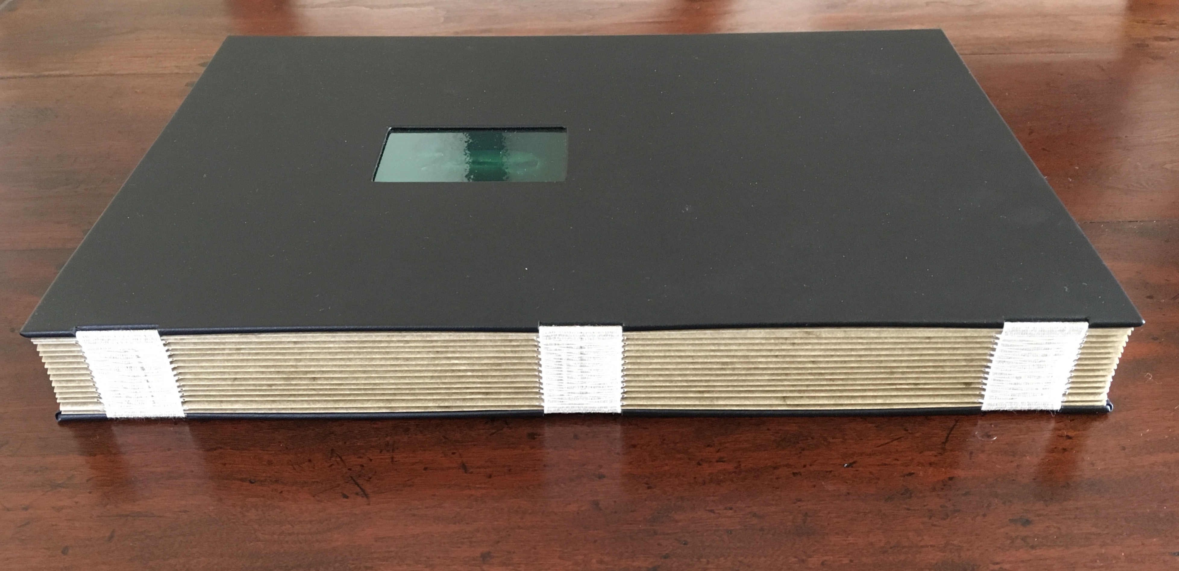 Book removed from case, viewed horizontally, spine showing