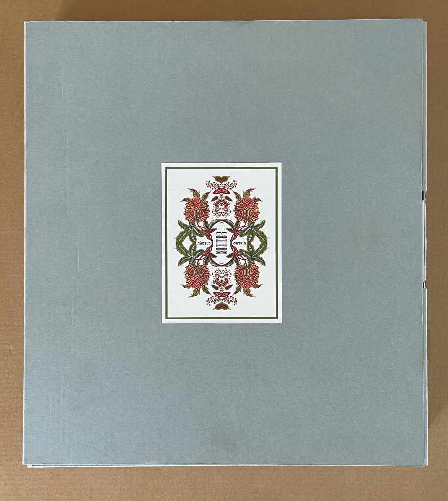 Cover of a decorative book with a gray background and an intricate floral design in the center featuring red flowers and green leaves.