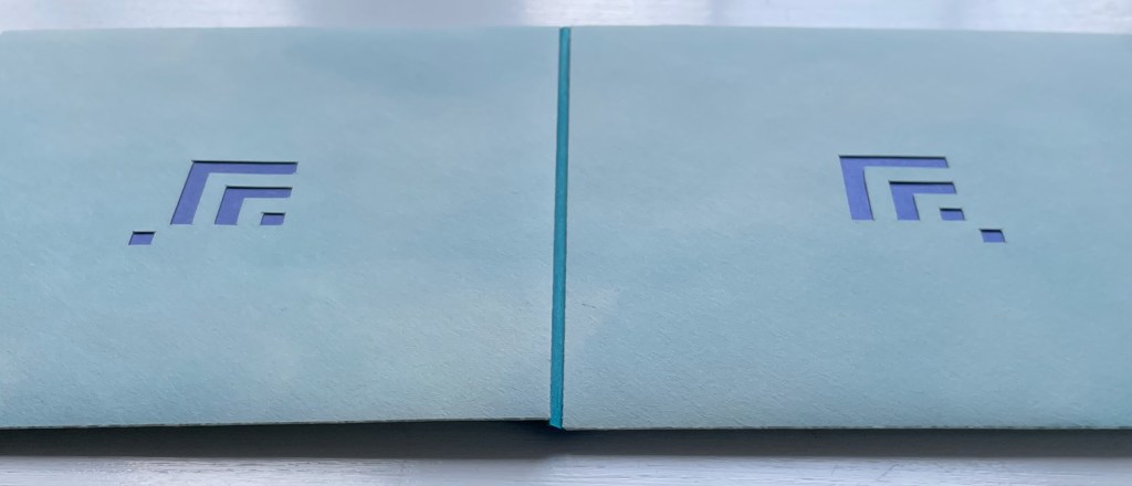 Close-up view of a blue folder with an abstract purple logo on the front, featuring geometric shapes.