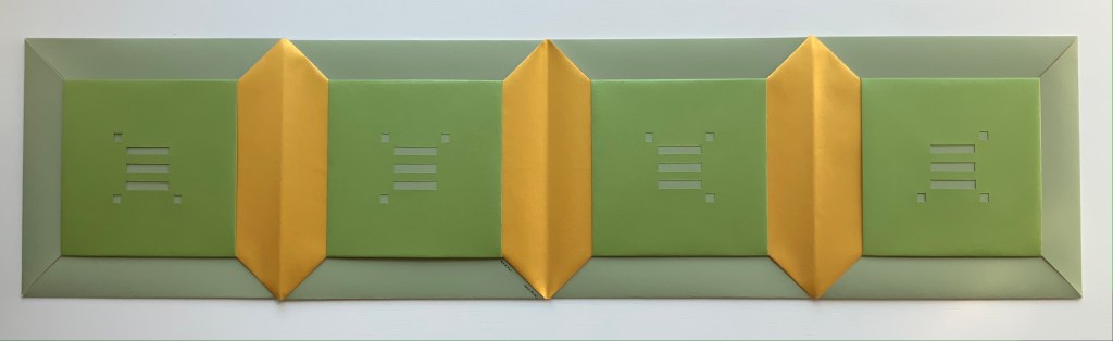 A dimensional art piece featuring a series of interlocking green and yellow shapes arranged in an abstract layout, with cut-out patterns revealing underlying layers.
