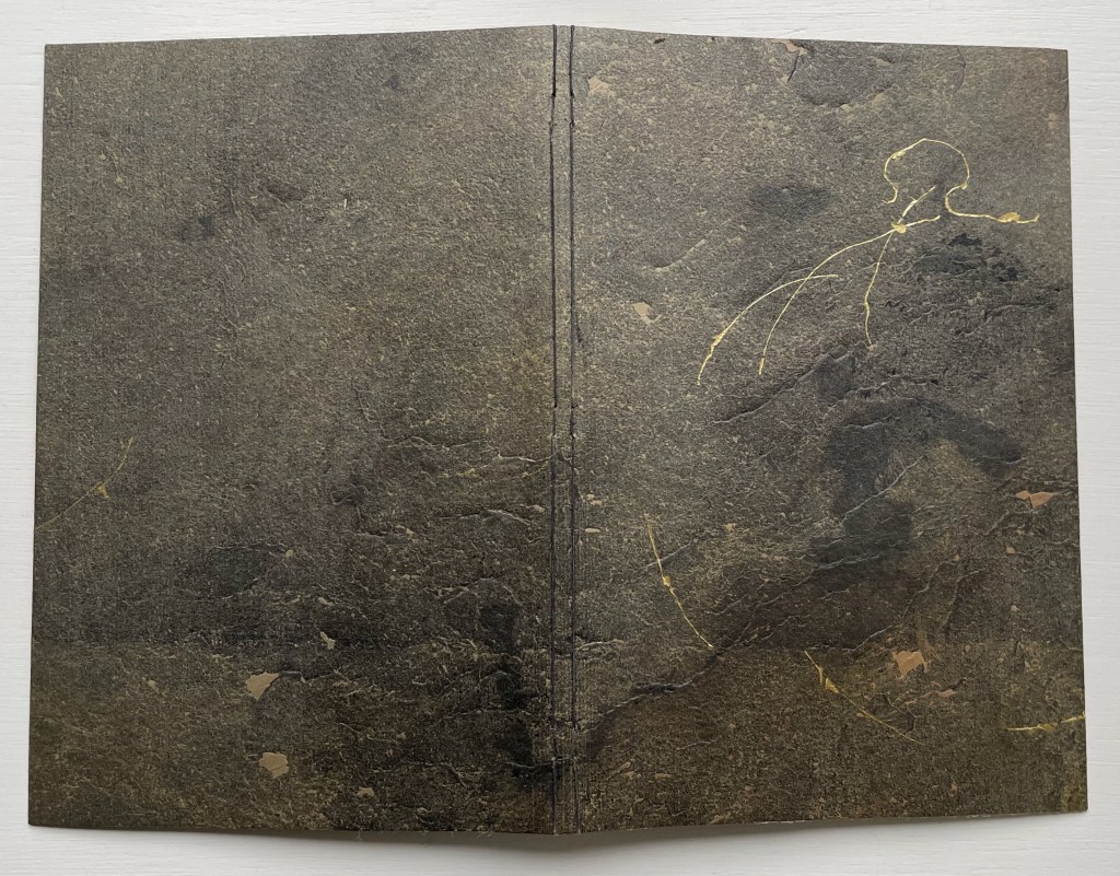 The cover of the book 'Amorous Embrace' (2023) by Suzanne Moore, featuring a textured stone-like finish with gold leaf accents and a minimalist line drawing.
