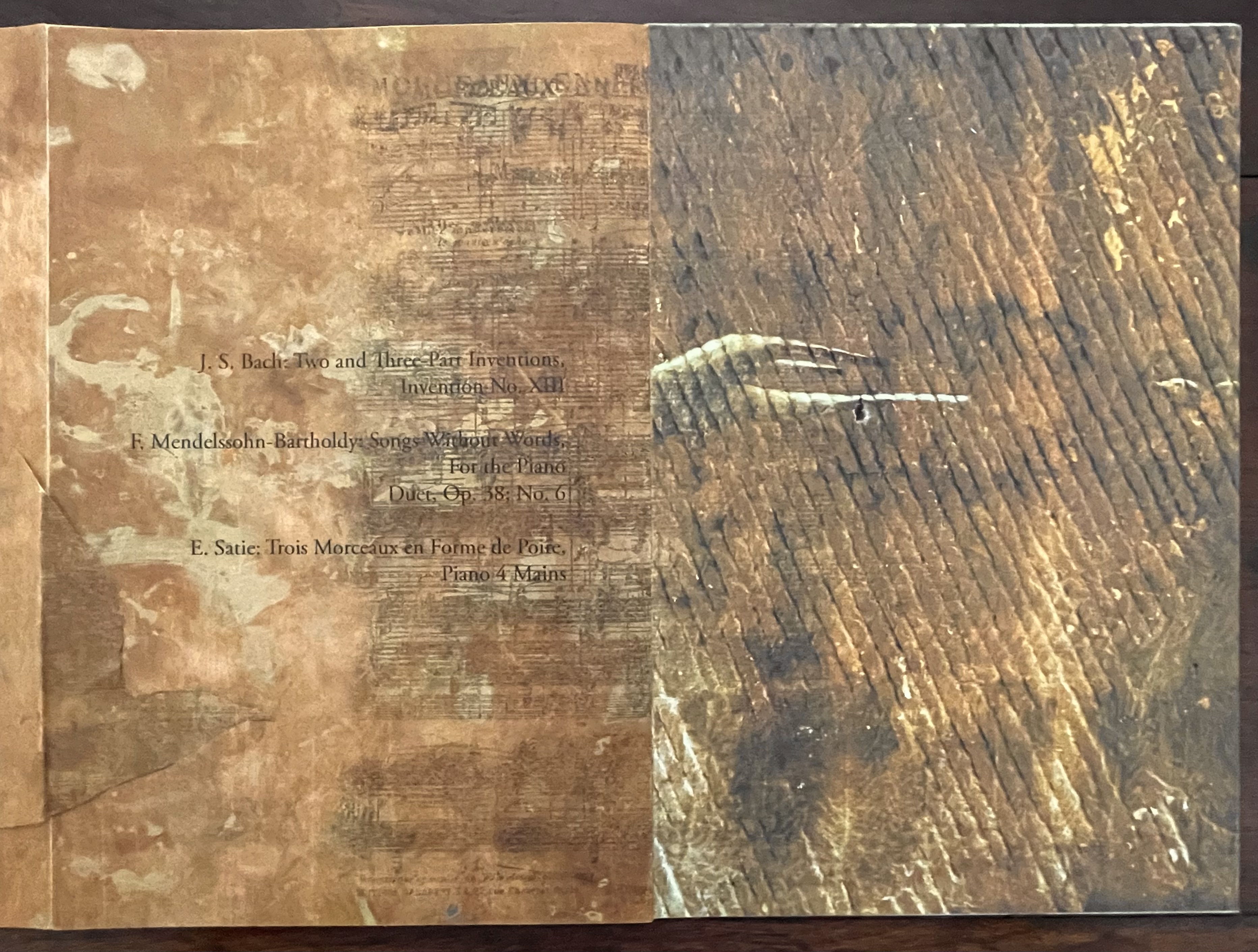 Cover of Marlene MacCallum's artist book featuring layered textures with titles of musical pieces by J.S. Bach, F. Mendelssohn-Bartholdy, and E. Satie, printed in black on a gold and brown abstract background.