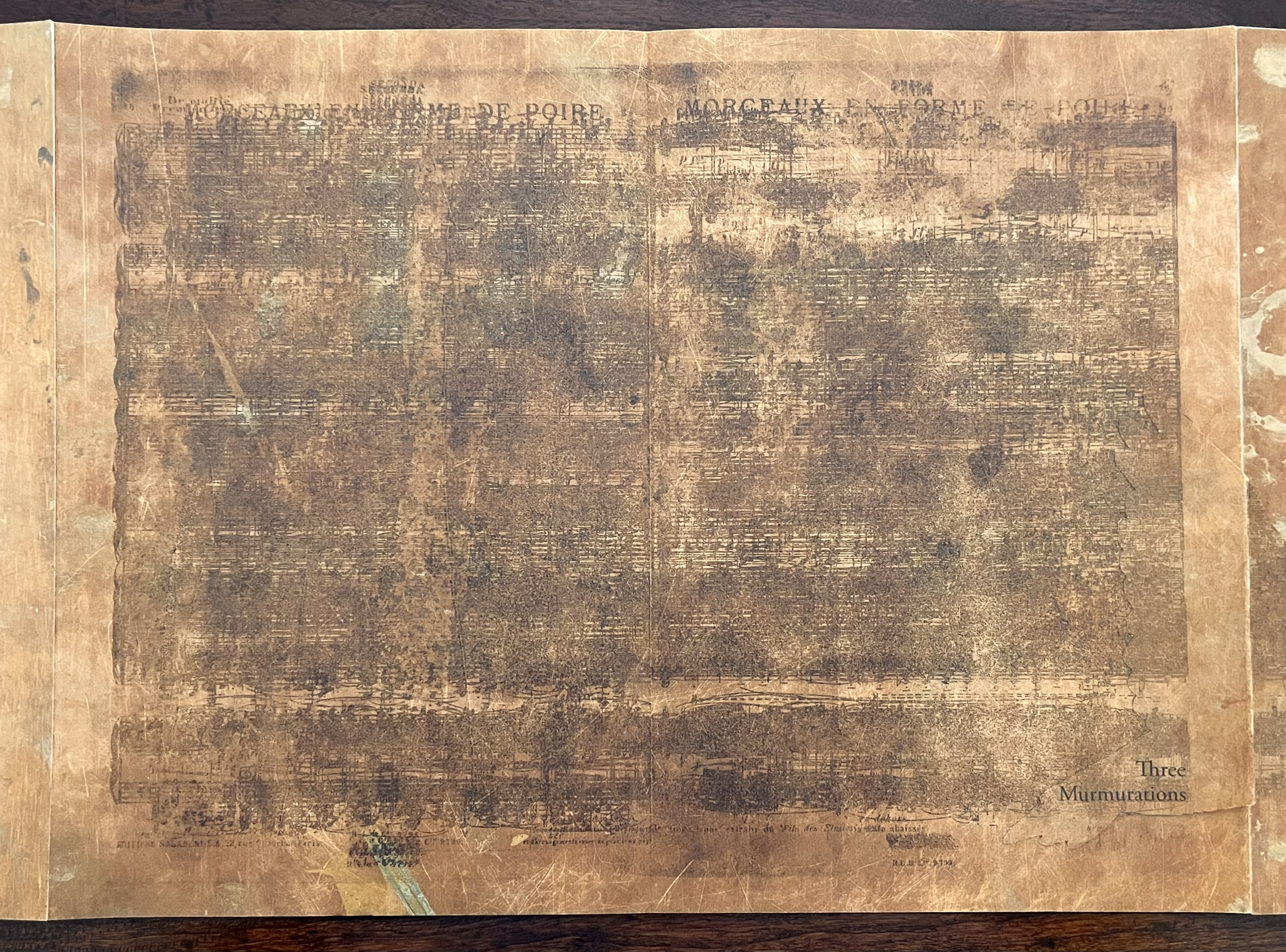 Faded sheet music from a handbound artist's book, featuring the title 'Three Murmurations' printed in the bottom right corner.