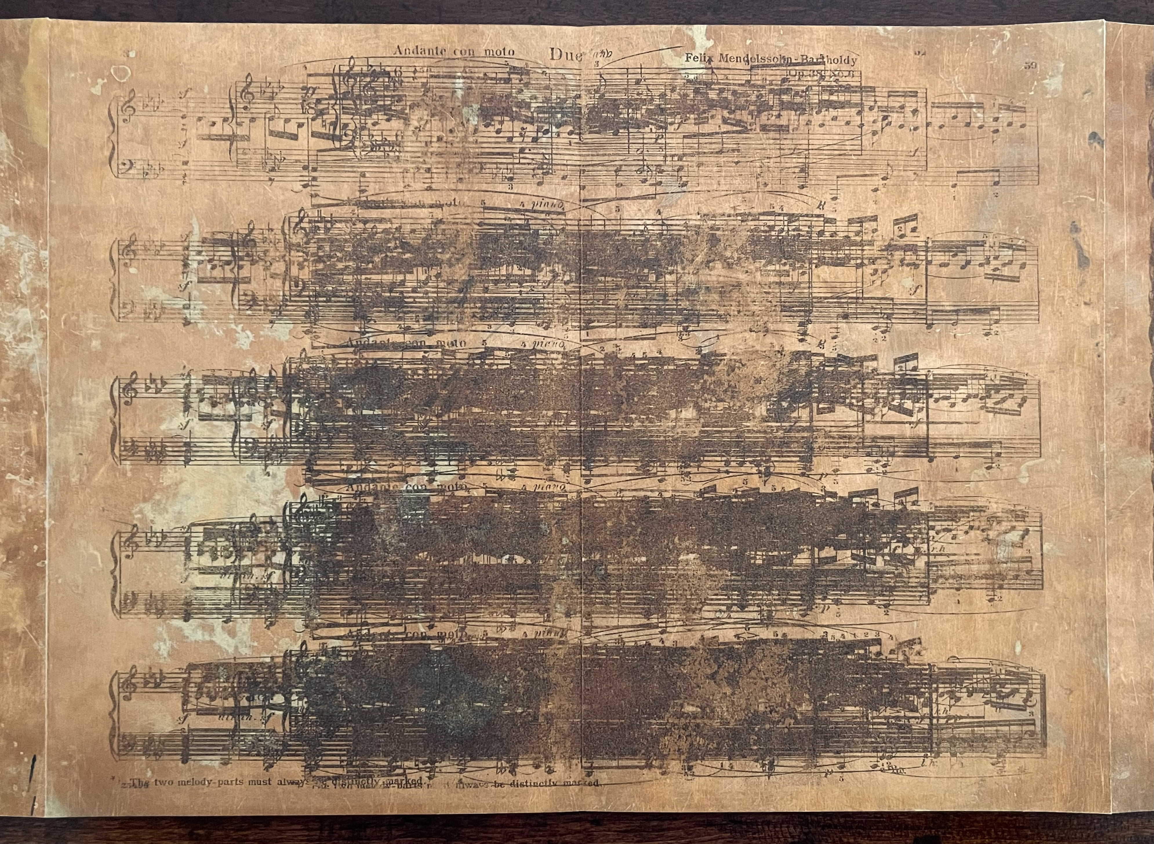 A vintage sheet of music featuring scores for Felix Mendelssohn, with significant areas obscured by smudges and discoloration, giving it an aged appearance.