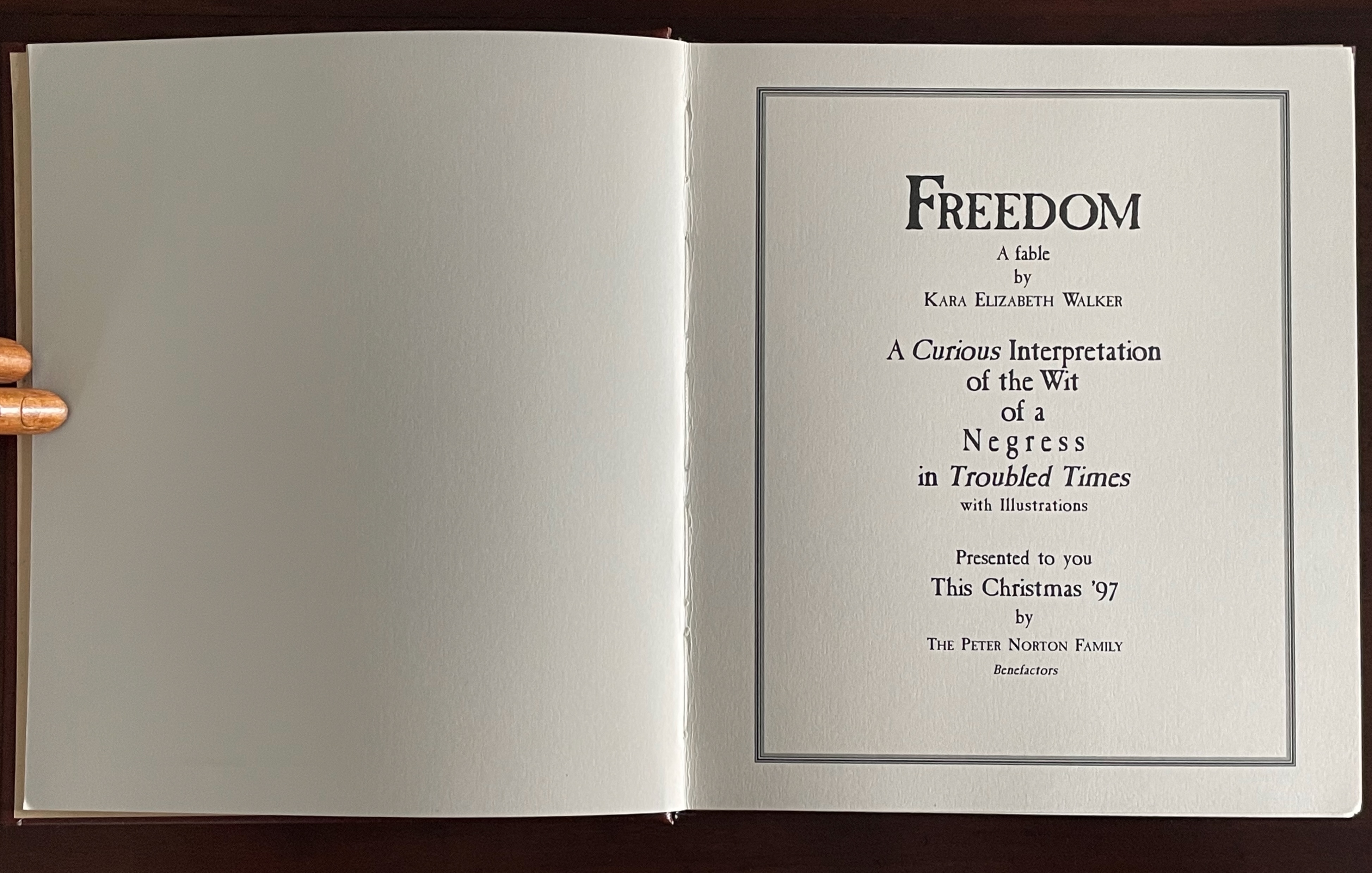 An open book page featuring the title 'Freedom' by Kara Elizabeth Walker, with the subtitle 'A Curious Interpretation of the Wit of a Negress in Troubled Times' and presented by The Peter Norton Family. The design includes elegant typography with borders.