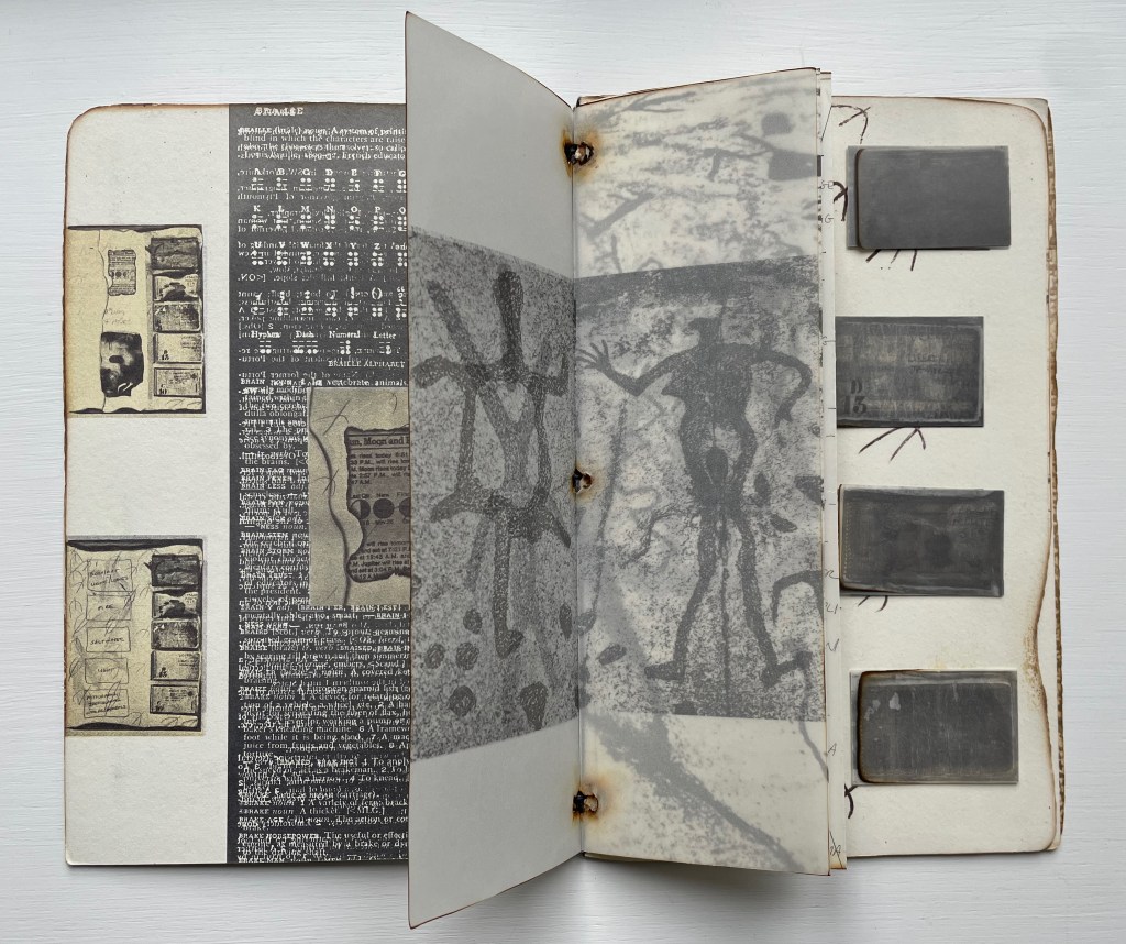 An open book displaying pages with sketches, text, and artistic depictions of human figures and shapes.