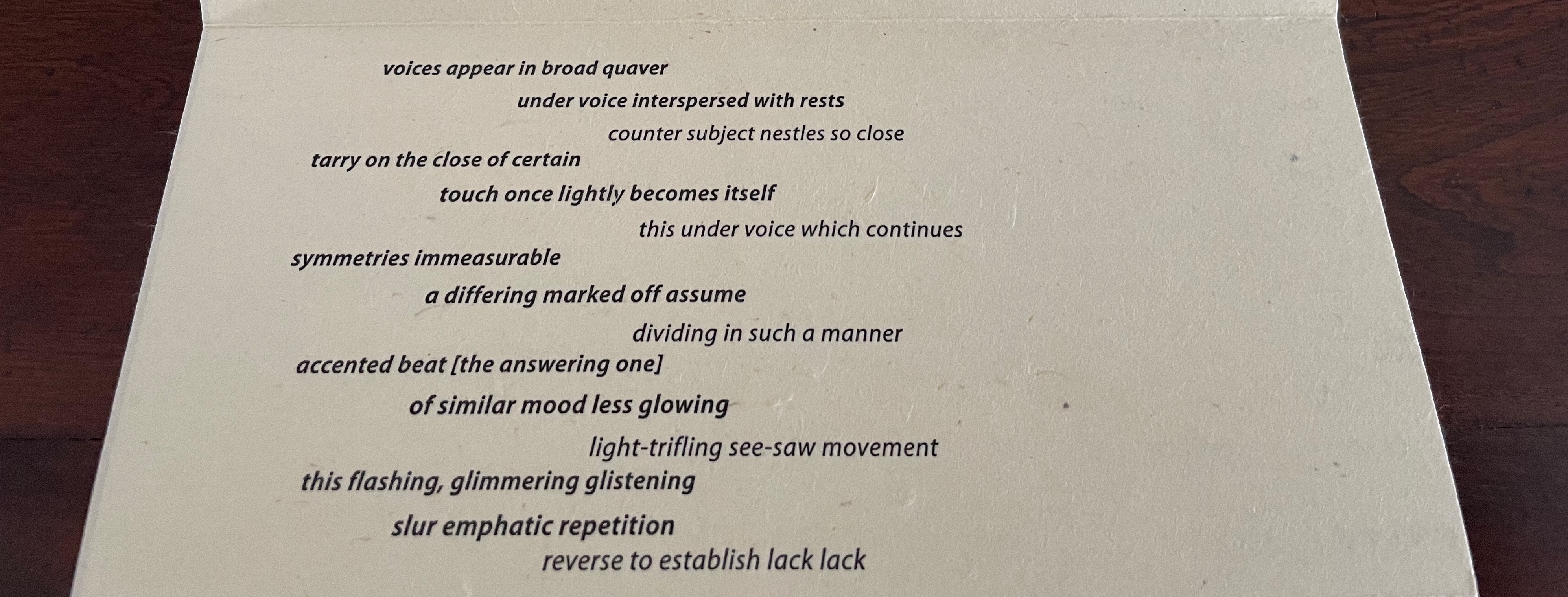 A close-up of a page containing a poem with various lines of text in a creative typography format.