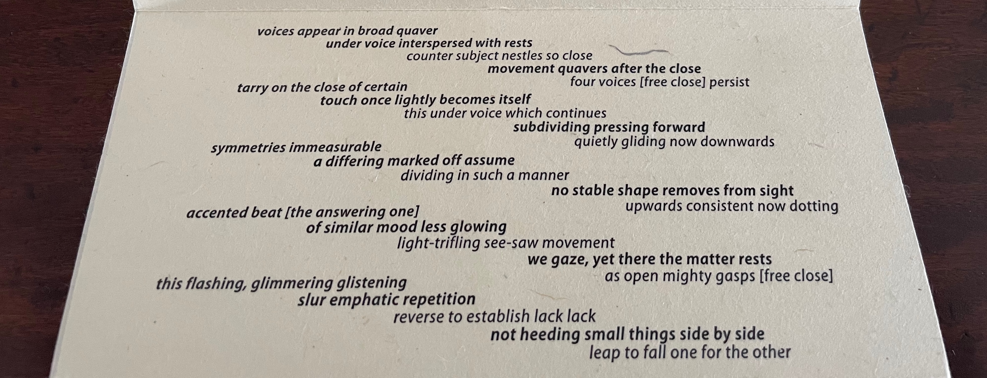 A close-up image of a textured paper with printed poetry or text, featuring varied font sizes and styles, conveying different rhythms and themes.