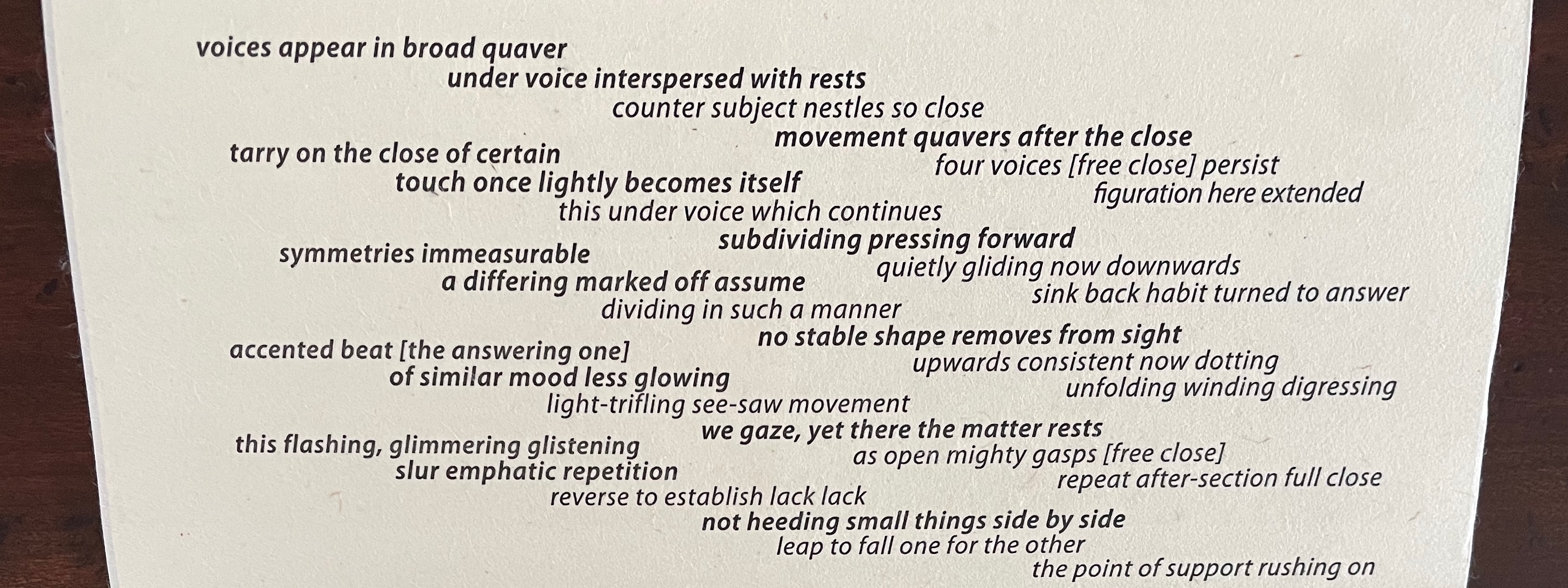 A close-up view of a page displaying a poem with various lines of text in different weights and styles on a textured background.