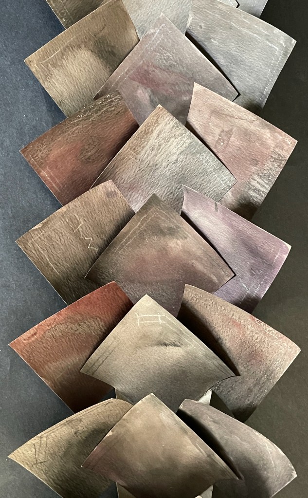 A collection of variously shaped and colored wooden pieces arranged in an overlapping pattern, showcasing a range of natural hues and textures.