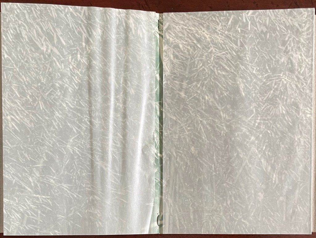 An open notebook with blank, textured pages featuring a subtle pattern.