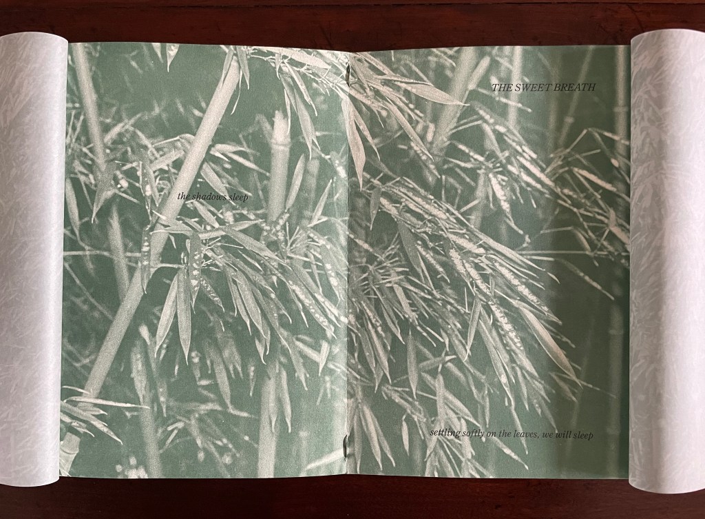 A close-up view of bamboo leaves in soft focus, with text overlay that reads 'THE SWEET BREATH' and 'the shadows sleep' on the left, and 'settling softly on the leaves, we will sleep' at the bottom.