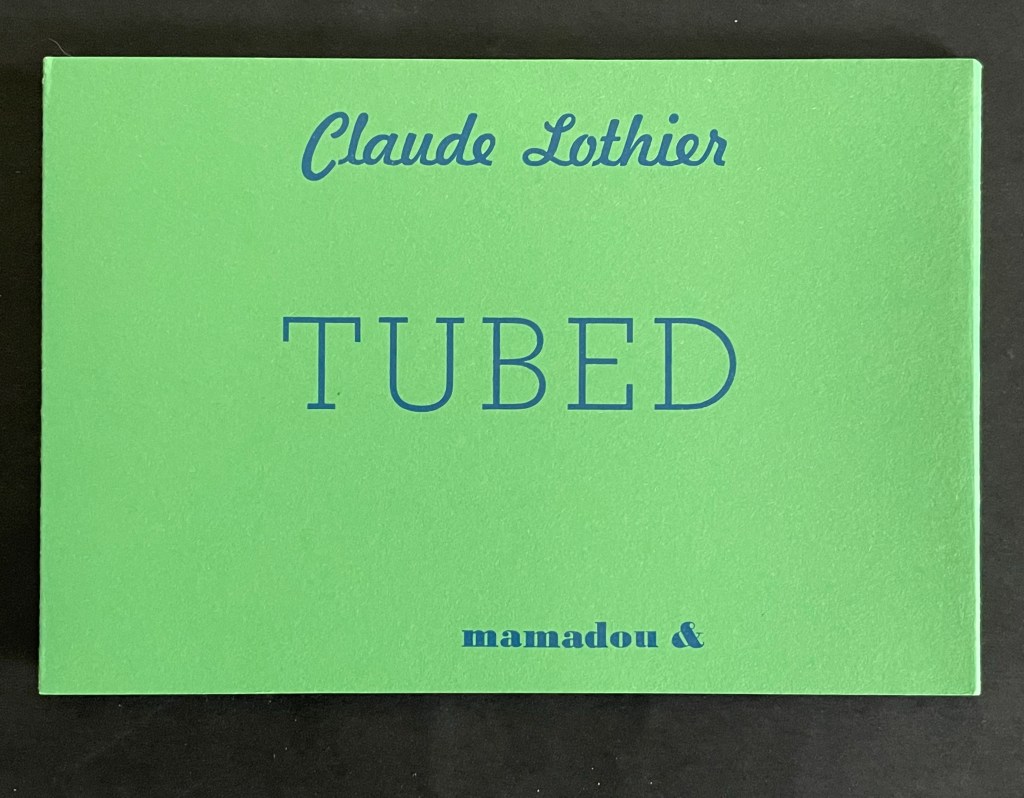 A green book cover featuring the title 'TUBED' in large blue letters, with the author's name 'Claude Lothier' and additional text 'mamadou &' displayed prominently.