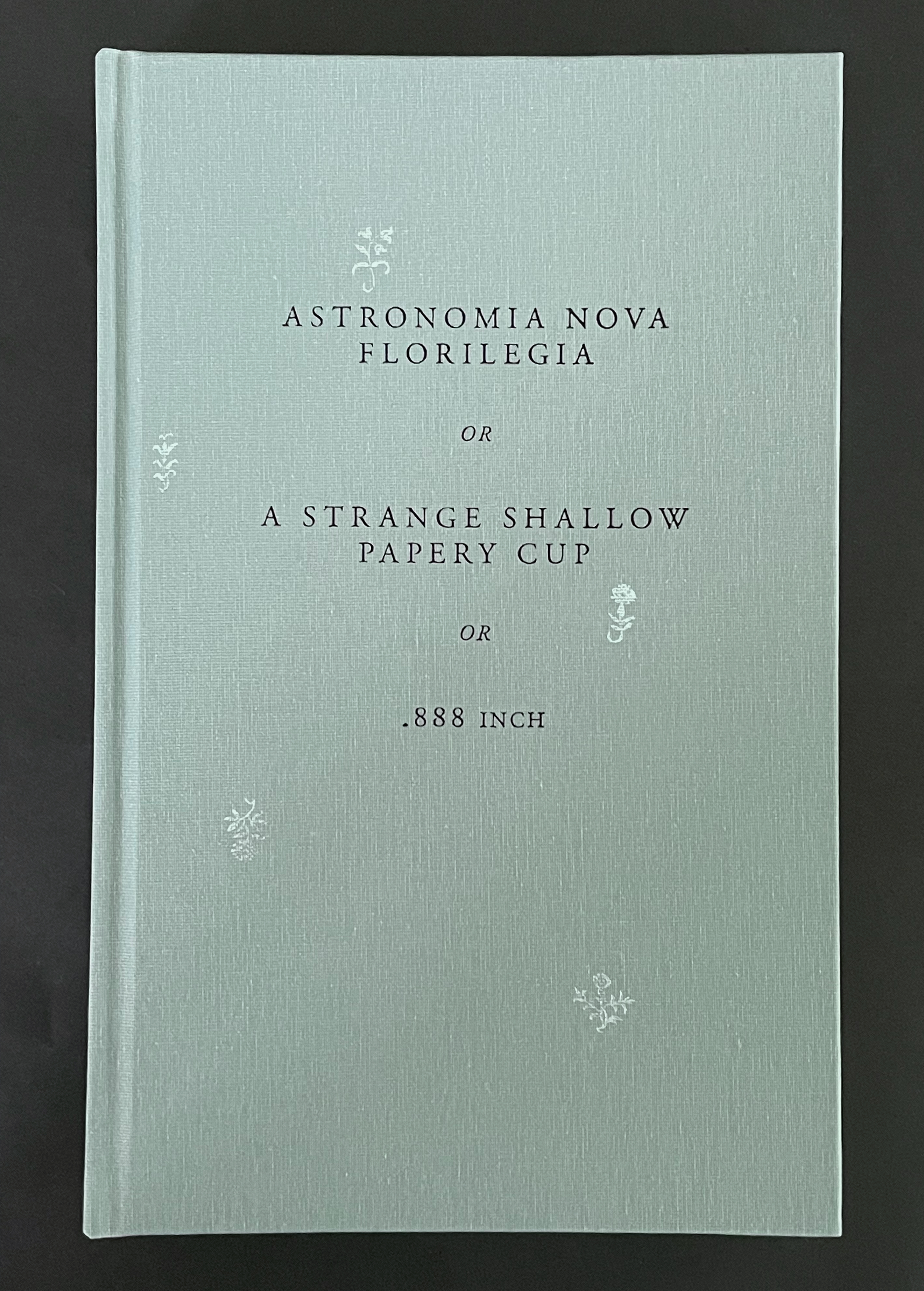 A hardcover book with a light blue-green cover featuring the title 'Astronomia Nova Florilegia or A Strange Shallow Papery Cup or .888 Inch' printed in black.