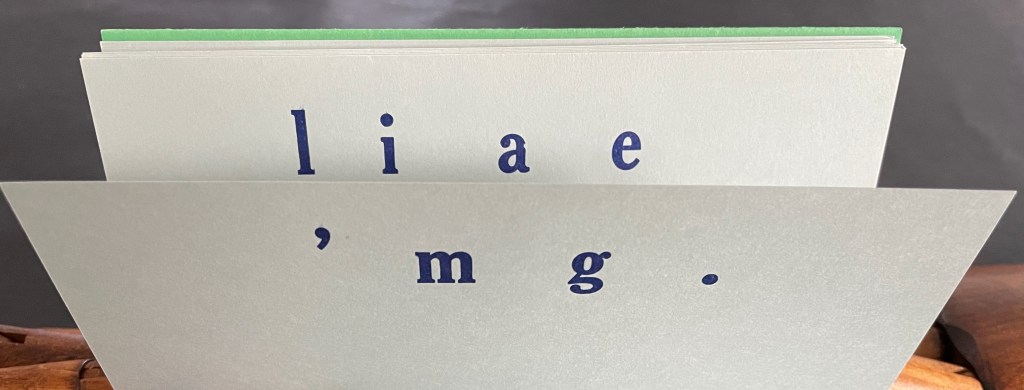 A close-up image of a stack of cards displaying letters and punctuation with a green top card.