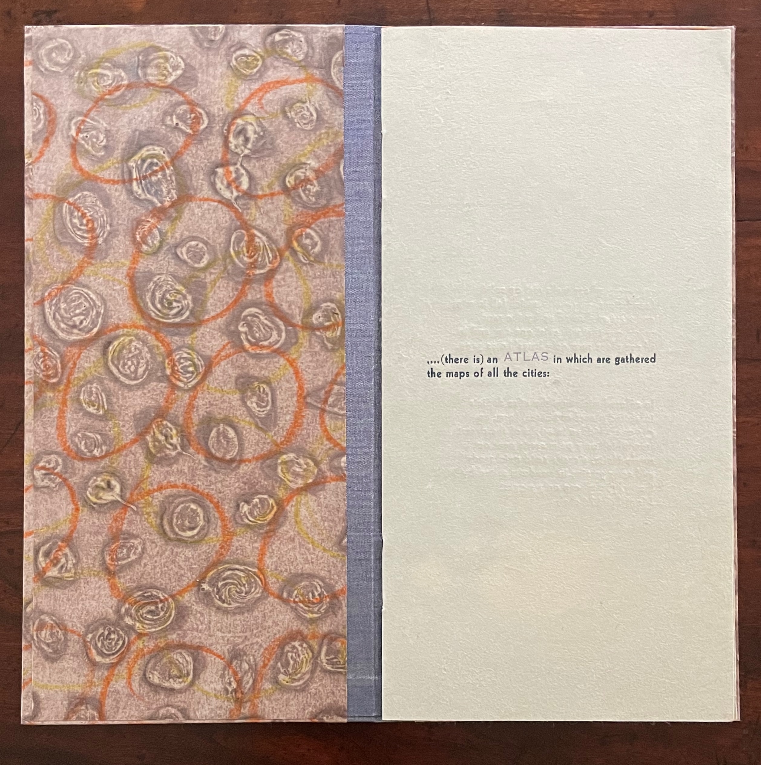 A textured book cover featuring a circular pattern in warm colors on the left and a light green page with text on the right.