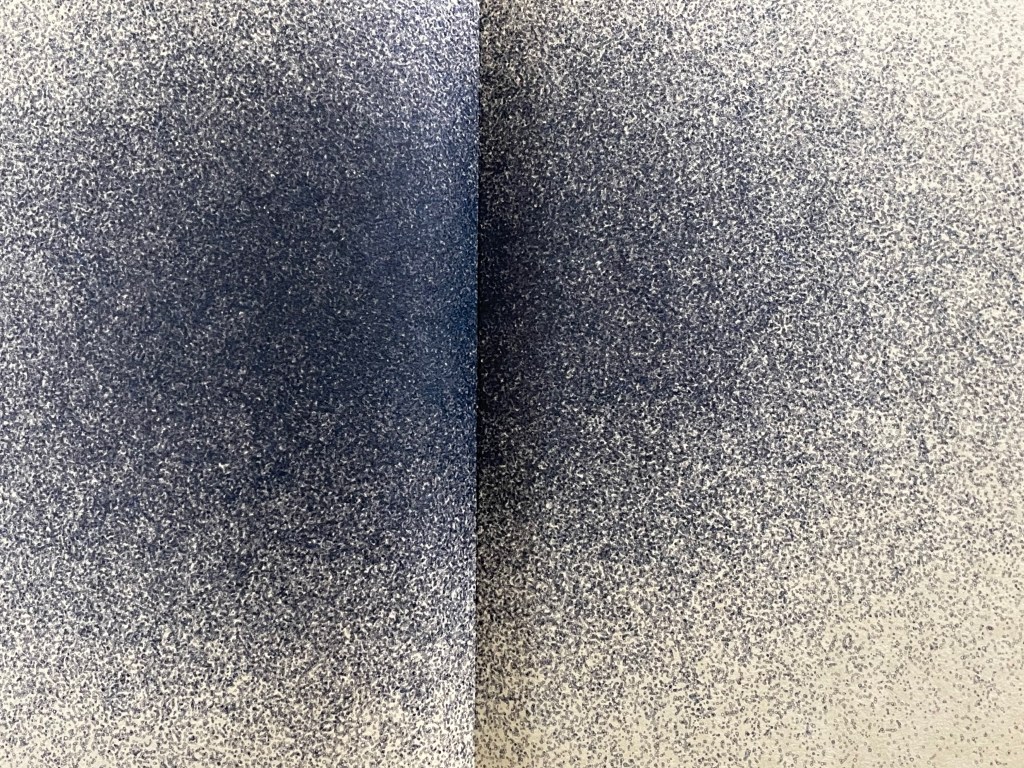A close-up view of a page with a textured pattern of dark blue and light gray speckles, creating a gradient effect.