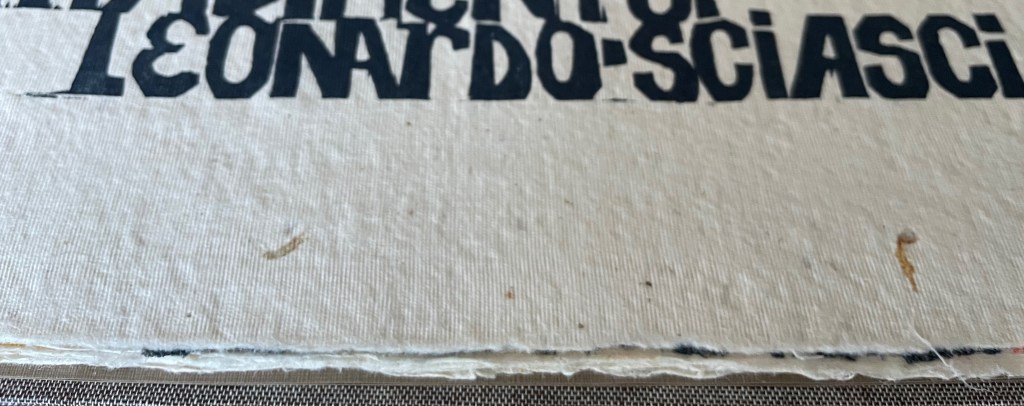 Close-up of an old book page with the title 'Leonardo-Sciascia' partially visible in bold black text.