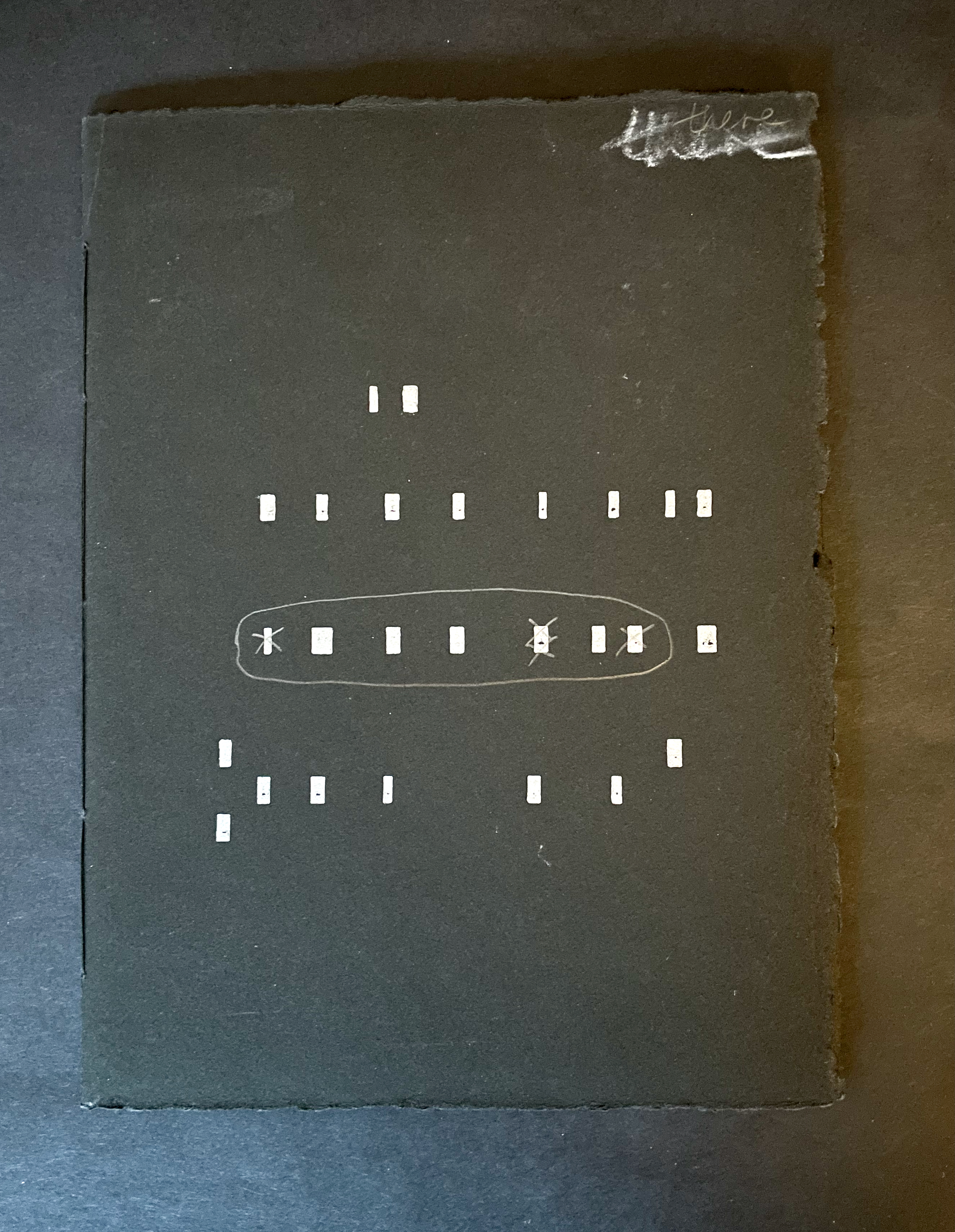 A black page featuring abstract white line drawings and symbols arranged in a symmetrical pattern.