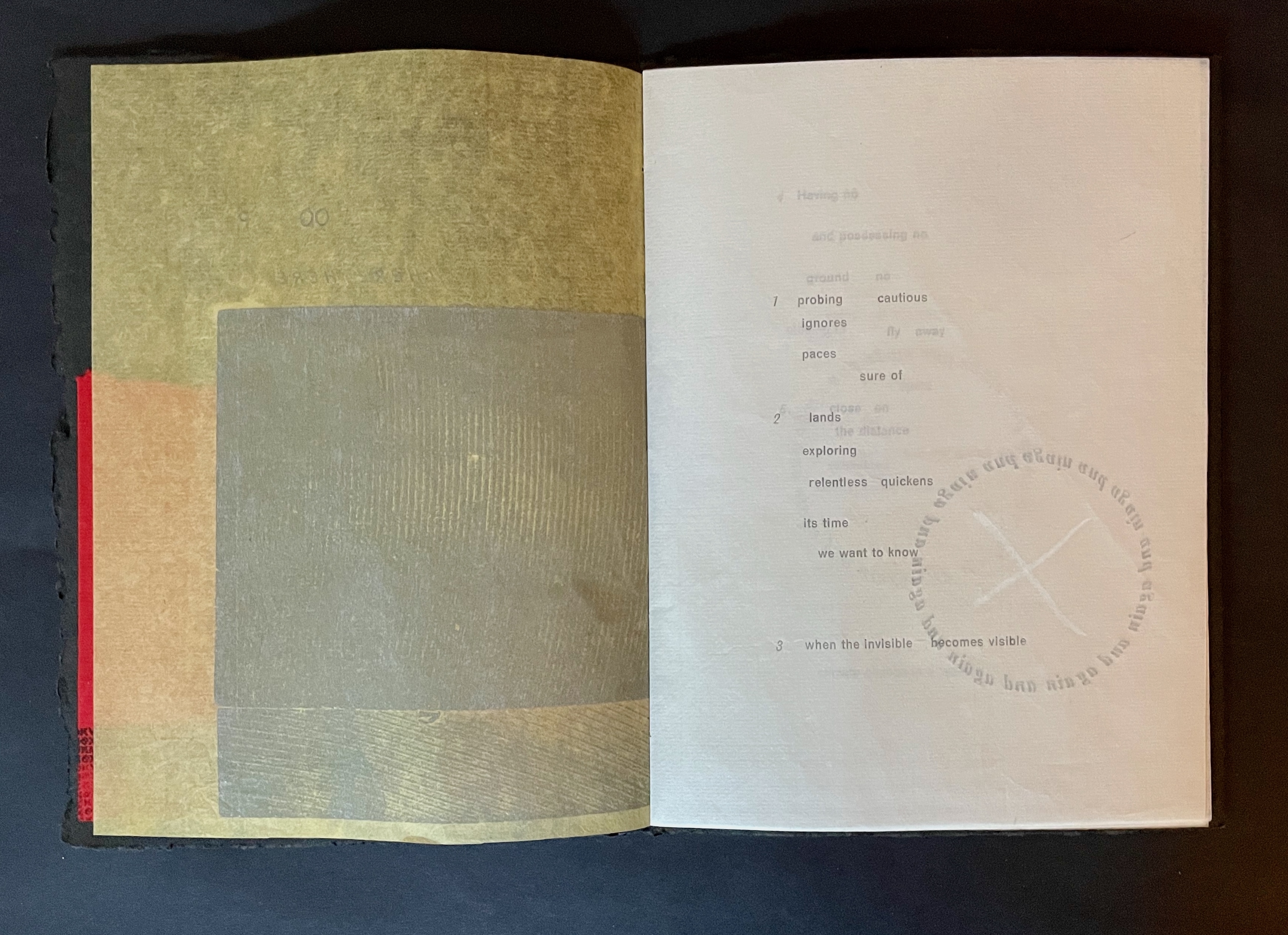 An open book displaying textured paper and printed text, with a combination of colors including yellow, beige, and red, emphasizing artistic presentation.