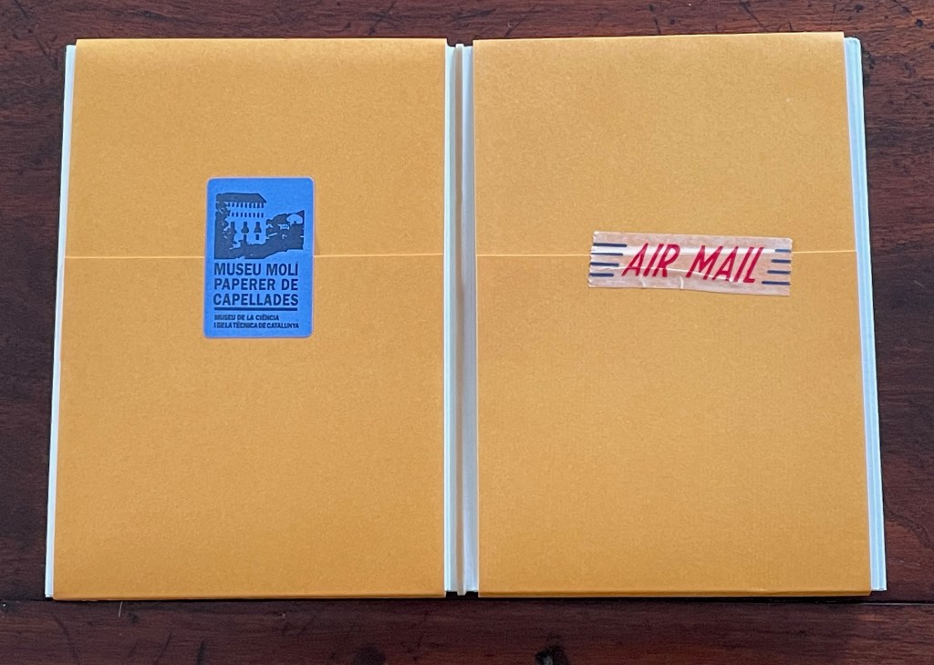 Two yellow envelopes side by side, one featuring a blue label that reads 'MUSEU MOLI PAPERER DE CAPELADES' and the other labeled 'AIR MAIL' with red text.