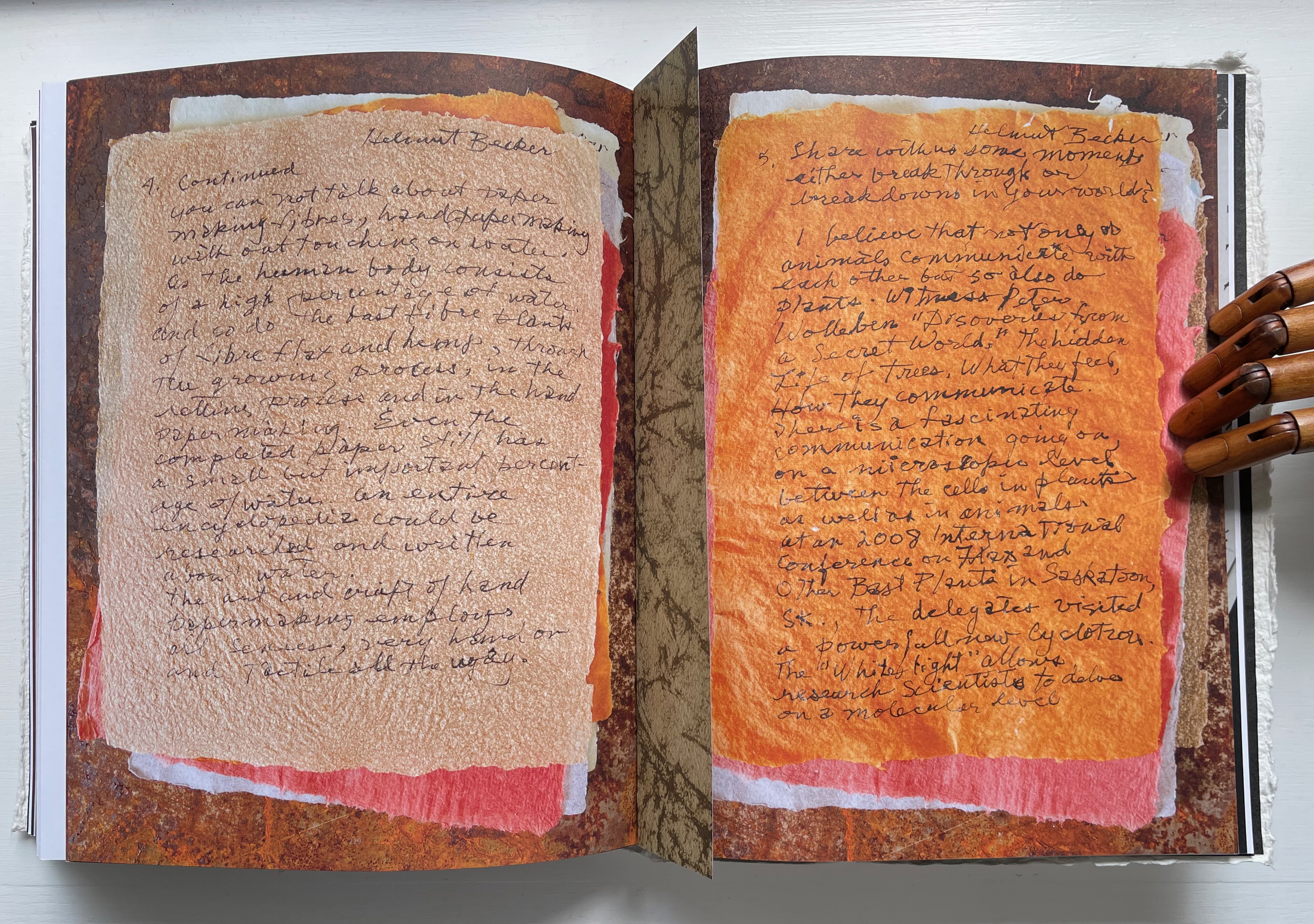 An open book displaying handwritten notes on textured paper, highlighted with colorful pages. The left page contains notes related to nature and communication, while the right page features reflections on trees and their interactions.