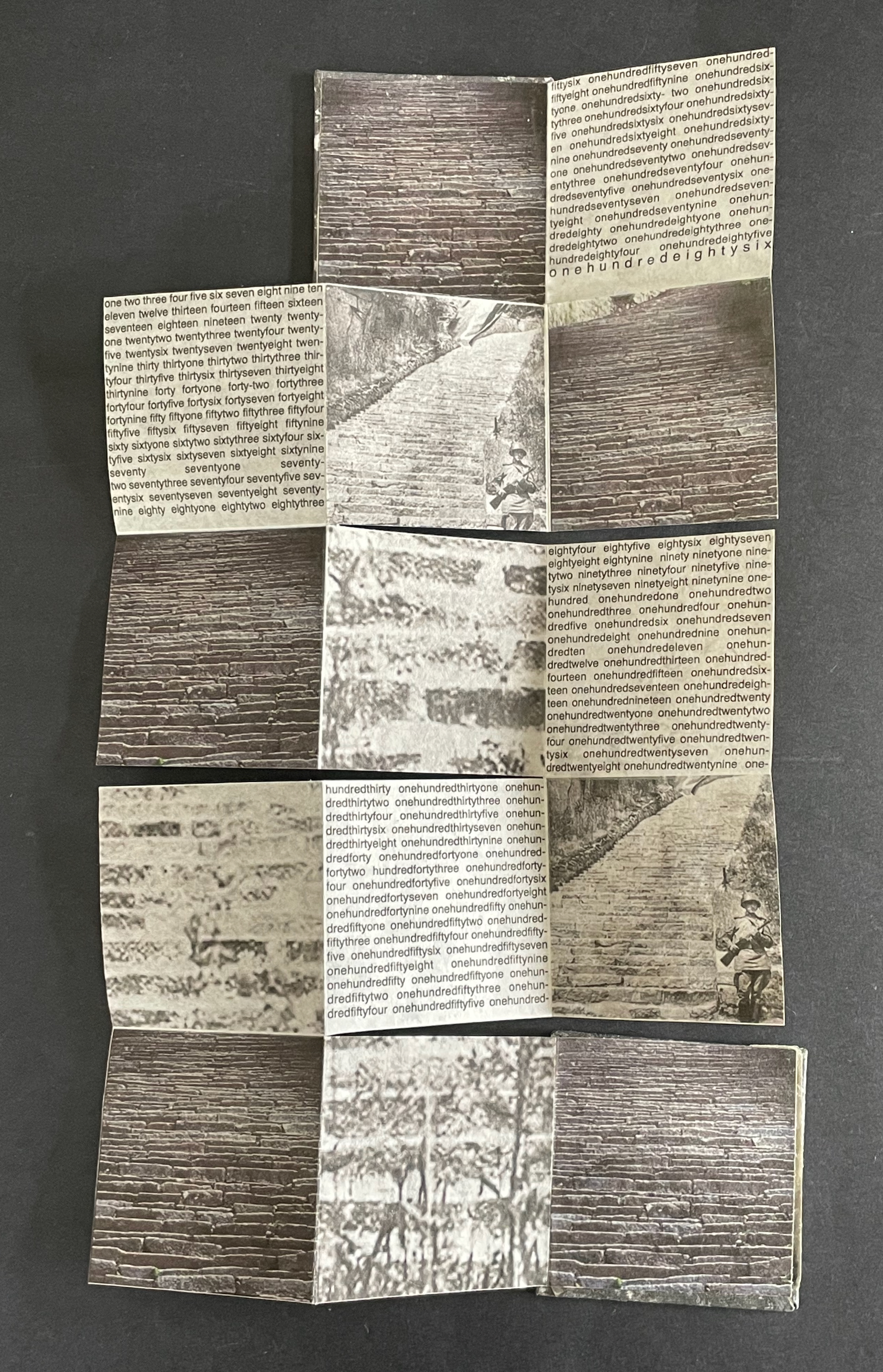 A folded piece of paper featuring a collage of images depicting stone steps and brick patterns, interspersed with text in a repeated, structured format.