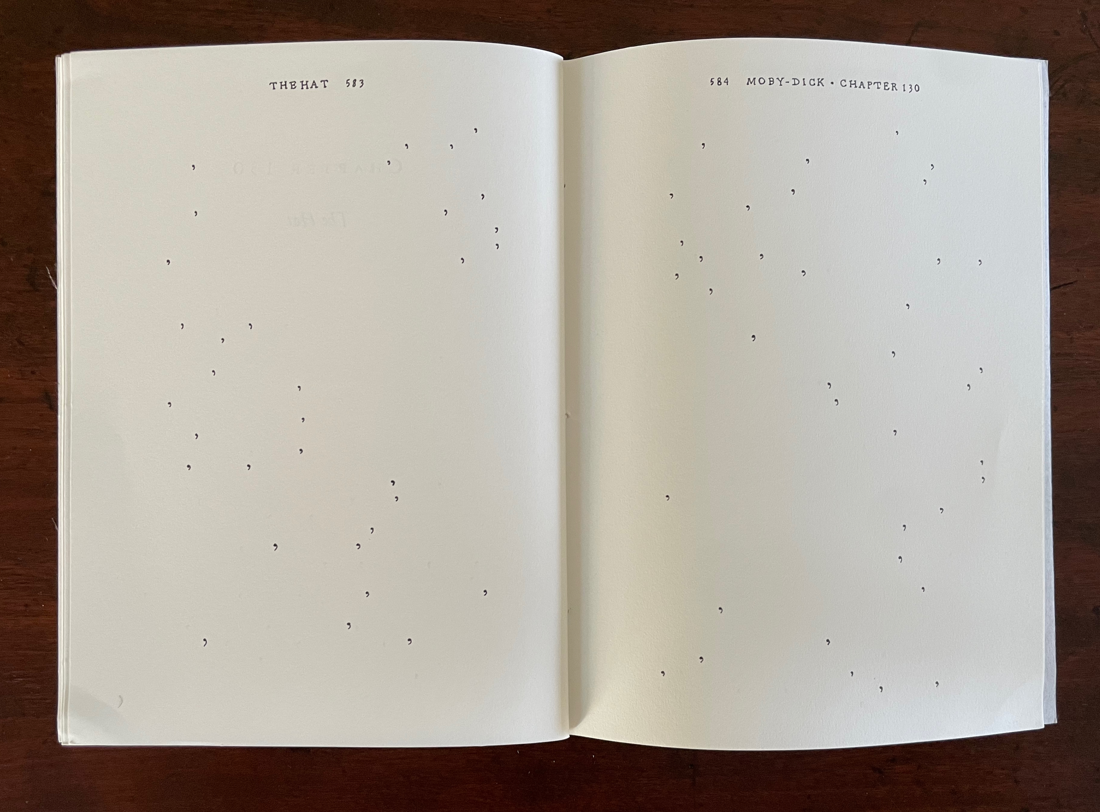 An open book showing two blank pages with scattered punctuation marks, including the title 'The Hat' on the left page and 'Moby-Dick Chapter 130' on the right page.