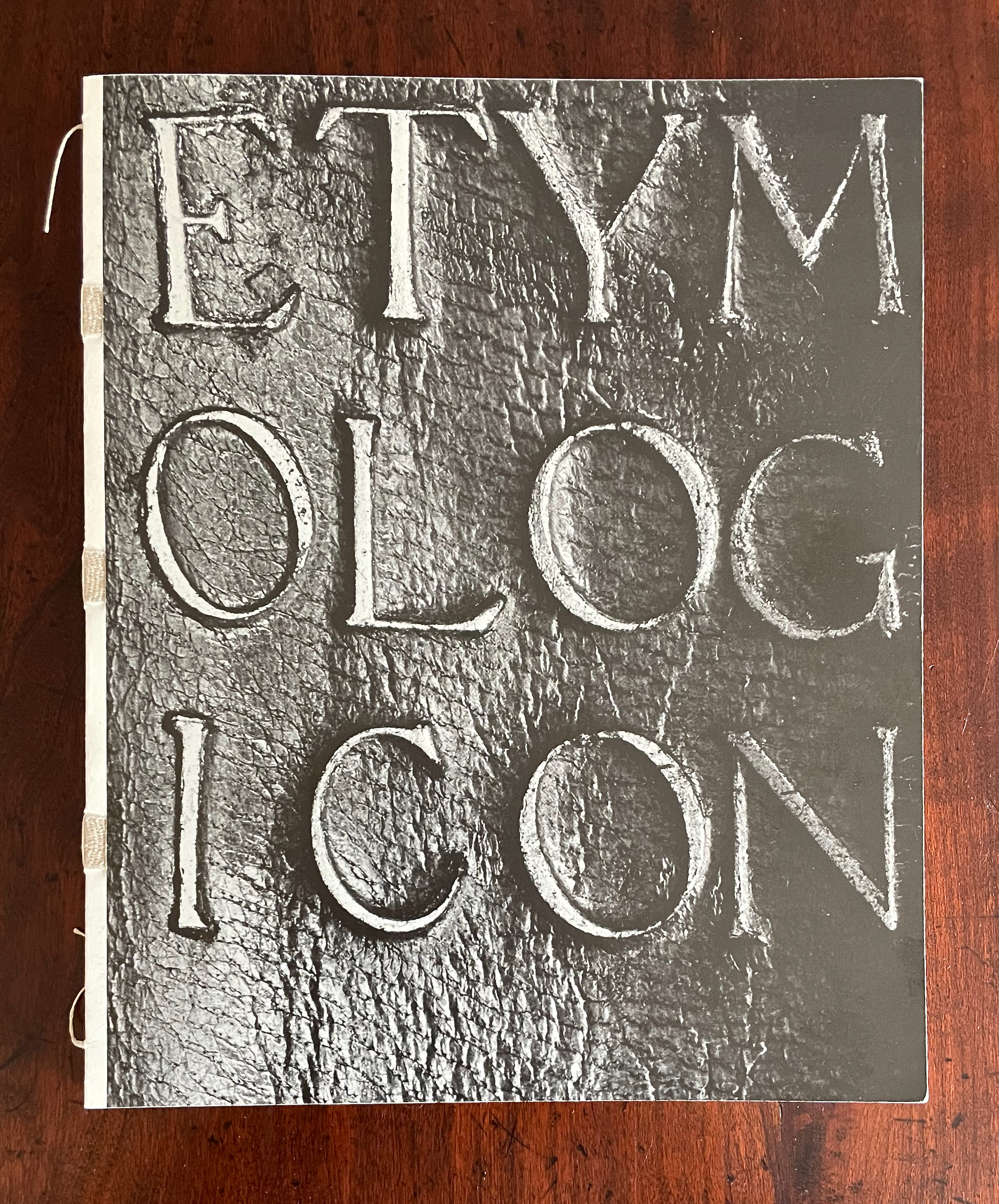 Cover of a book titled 'ETYM OLOG ICON' featuring embossed letters on a textured black background.