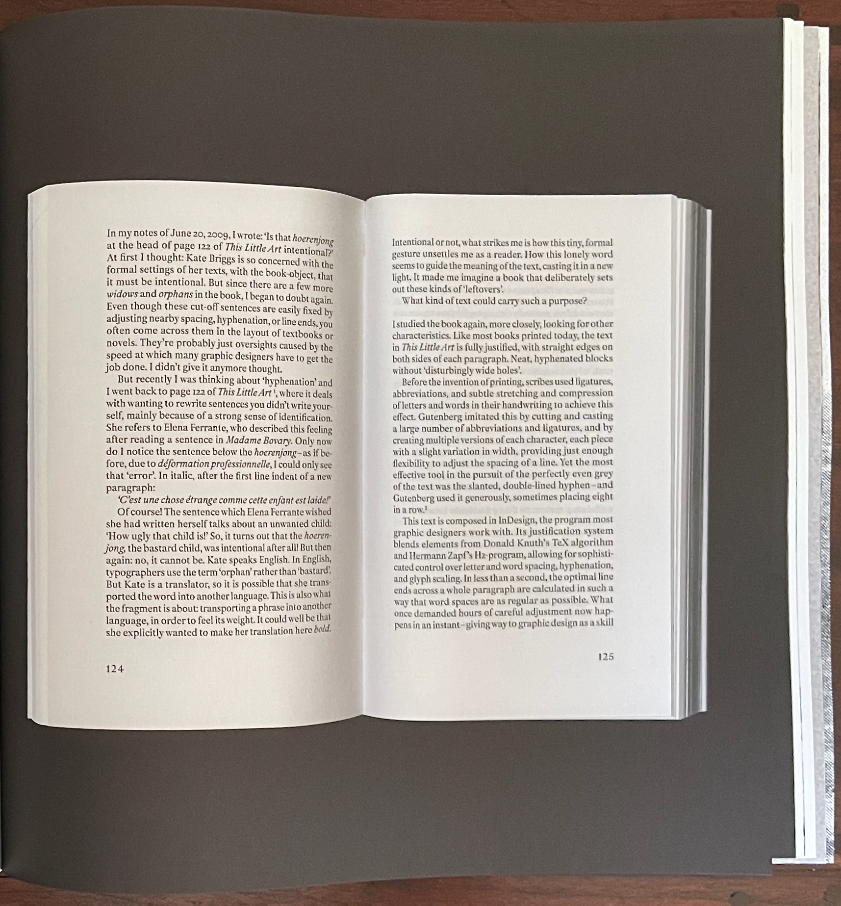 A close-up view of an open book's pages, discussing graphic design principles related to typography and formatting, with visible text and page numbers 124 and 125.