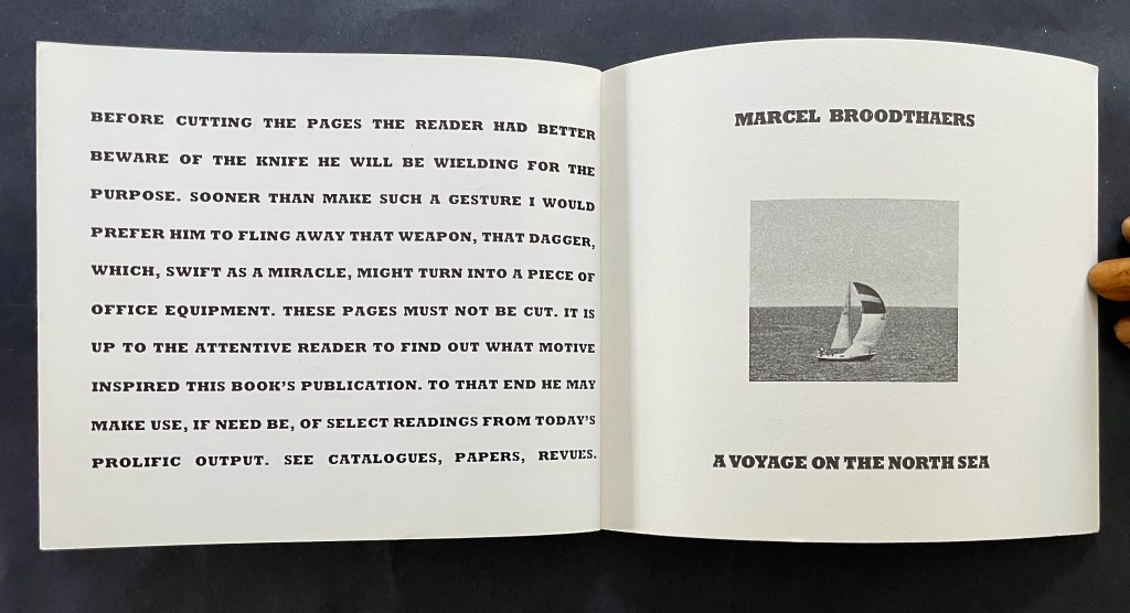 Open book page featuring bold text warning readers about cutting pages, accompanied by a small black and white image of a sailboat on the sea. Title and author, Marcel Broodthaers, displayed prominently.