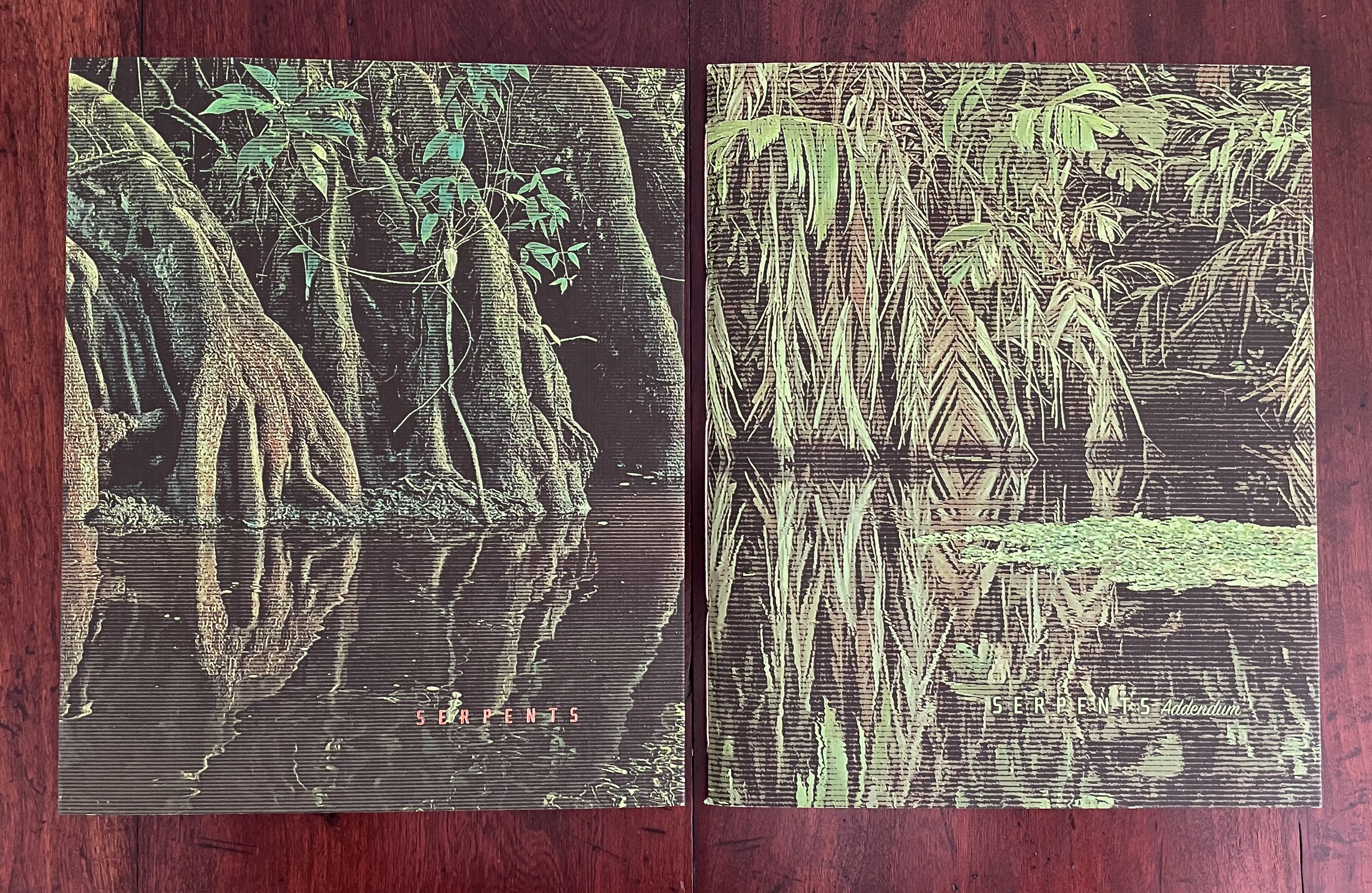Two illustrated covers for a publication titled 'Serpents' and 'Serpents Addendum,' featuring detailed depictions of mangrove roots and aquatic plants reflecting in water.