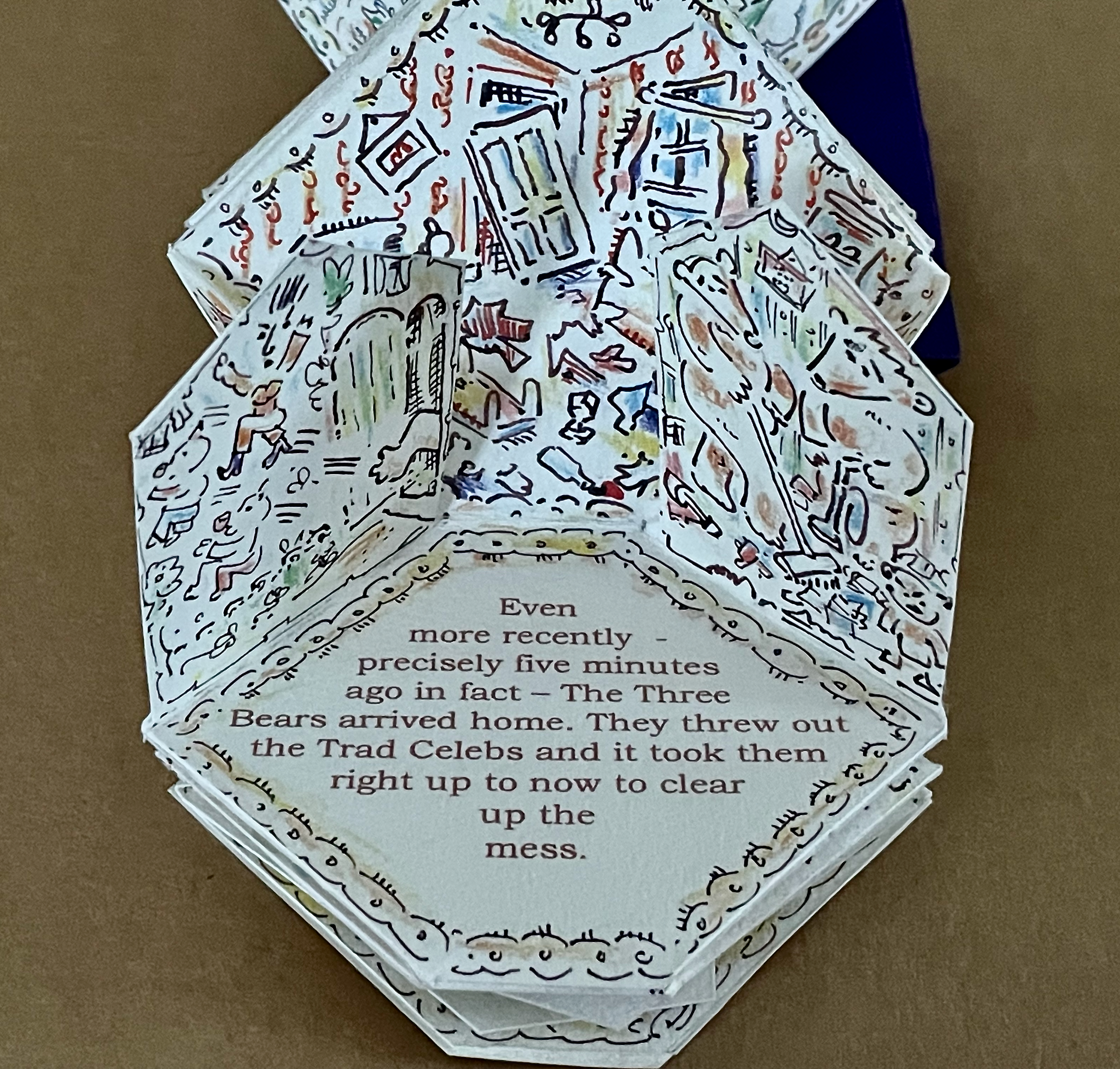 A pop-up book page with colorful illustrations depicting a chaotic scene inside a house, alongside text narrating a story about The Three Bears arriving home and clearing up a mess.