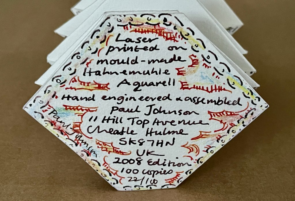 Close-up of a hexagonal card featuring handwritten text and colorful borders, indicating it was laser printed on mould-made Hahnemühle Aquarell paper, and includes details about the artist Paul Johnson, location, and edition information.