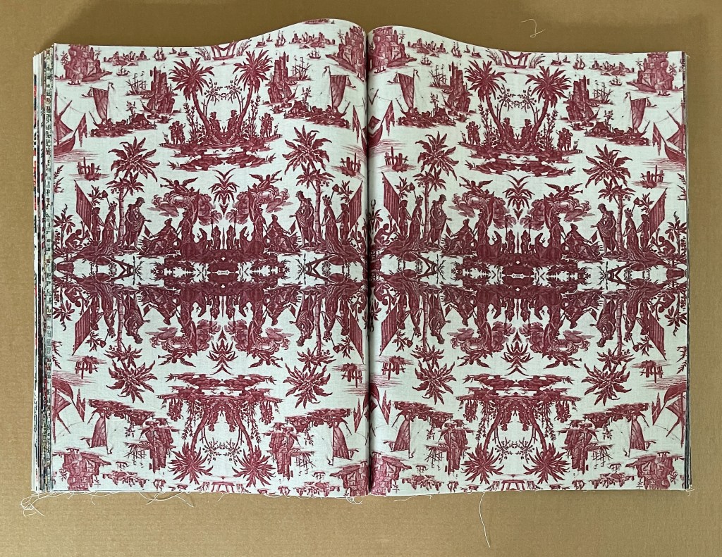An open book displaying a vibrant, symmetrical design with red illustrations of people, ships, and palm trees against a light background.