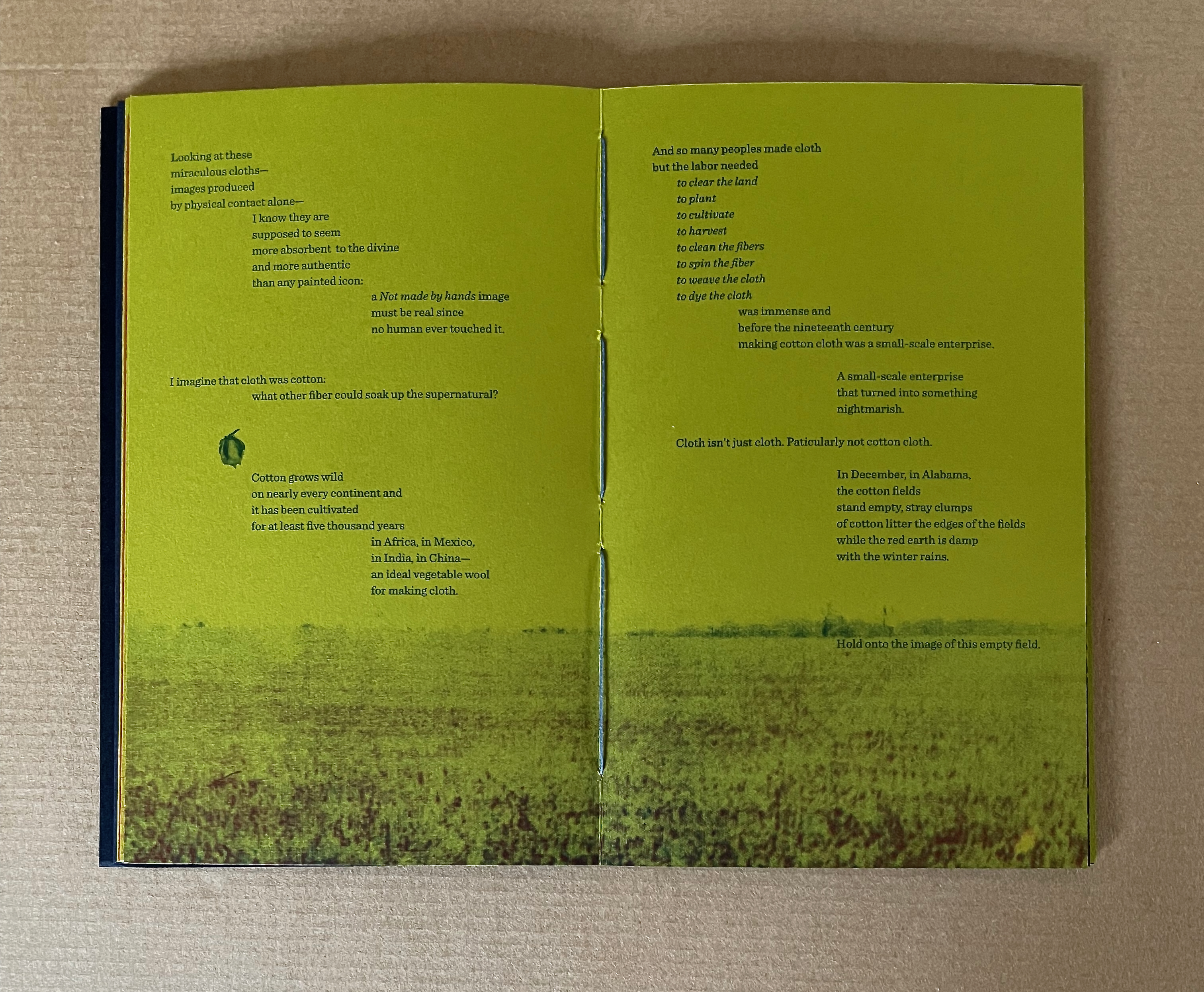 An open book with yellow pages containing text about the significance of cloth and cotton production, alongside a faded image of a cotton field.