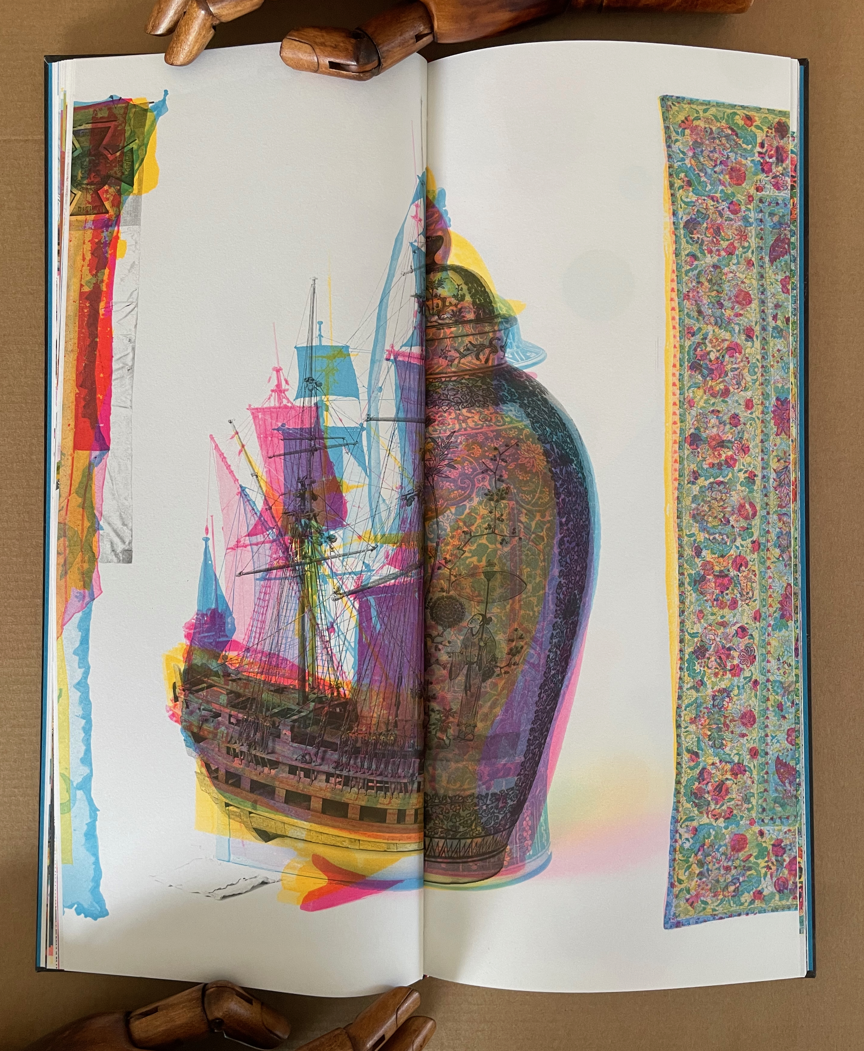 An open book featuring a colorful artistic composition of a ship and a decorative vase, surrounded by abstract patterns and vibrant hues.