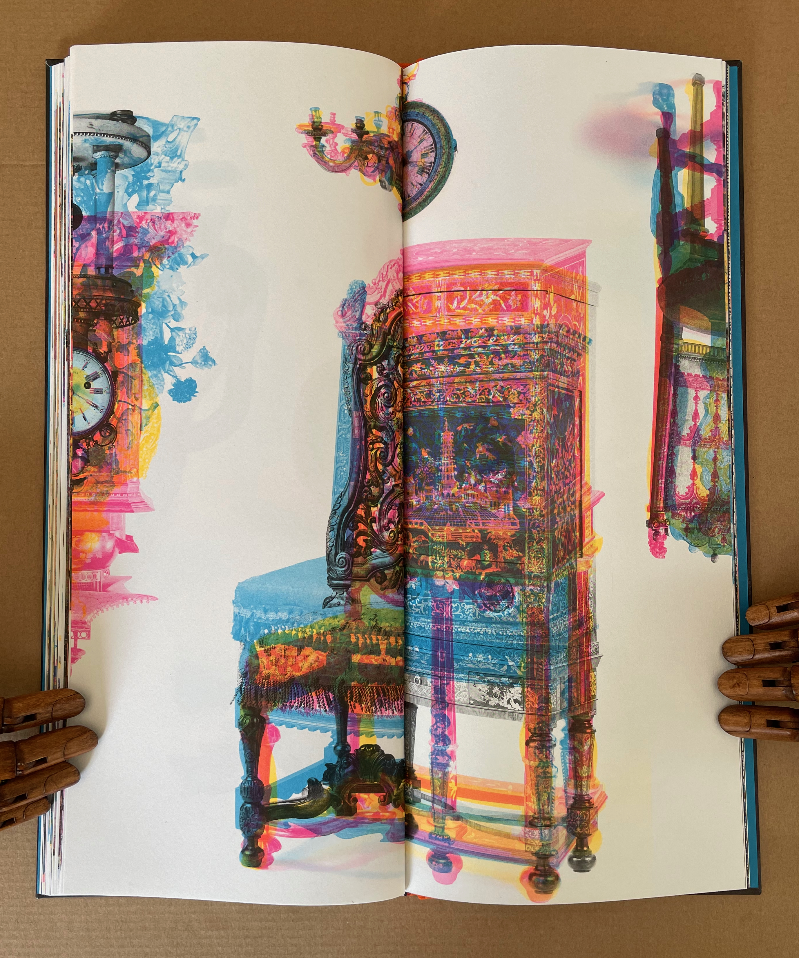 A vivid and abstract image of an open book displaying colorful illustrations of ornate furniture, including a chair and a decorative cabinet, with artistic layering and blending of colors.