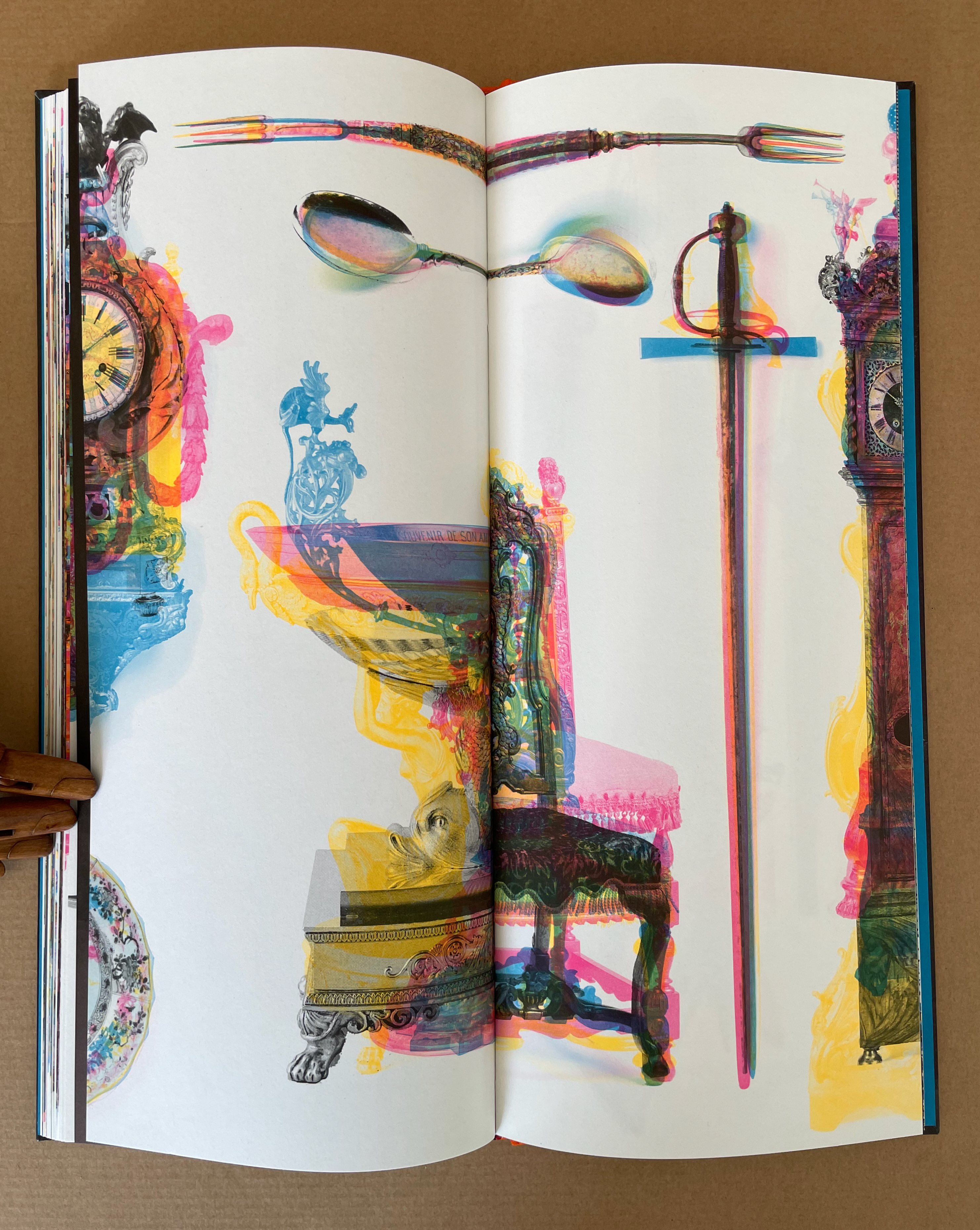 An artistic spread in a book featuring vibrant, abstract illustrations of various ornate objects including a clock, cutlery, and decorative furniture against a colorful background.