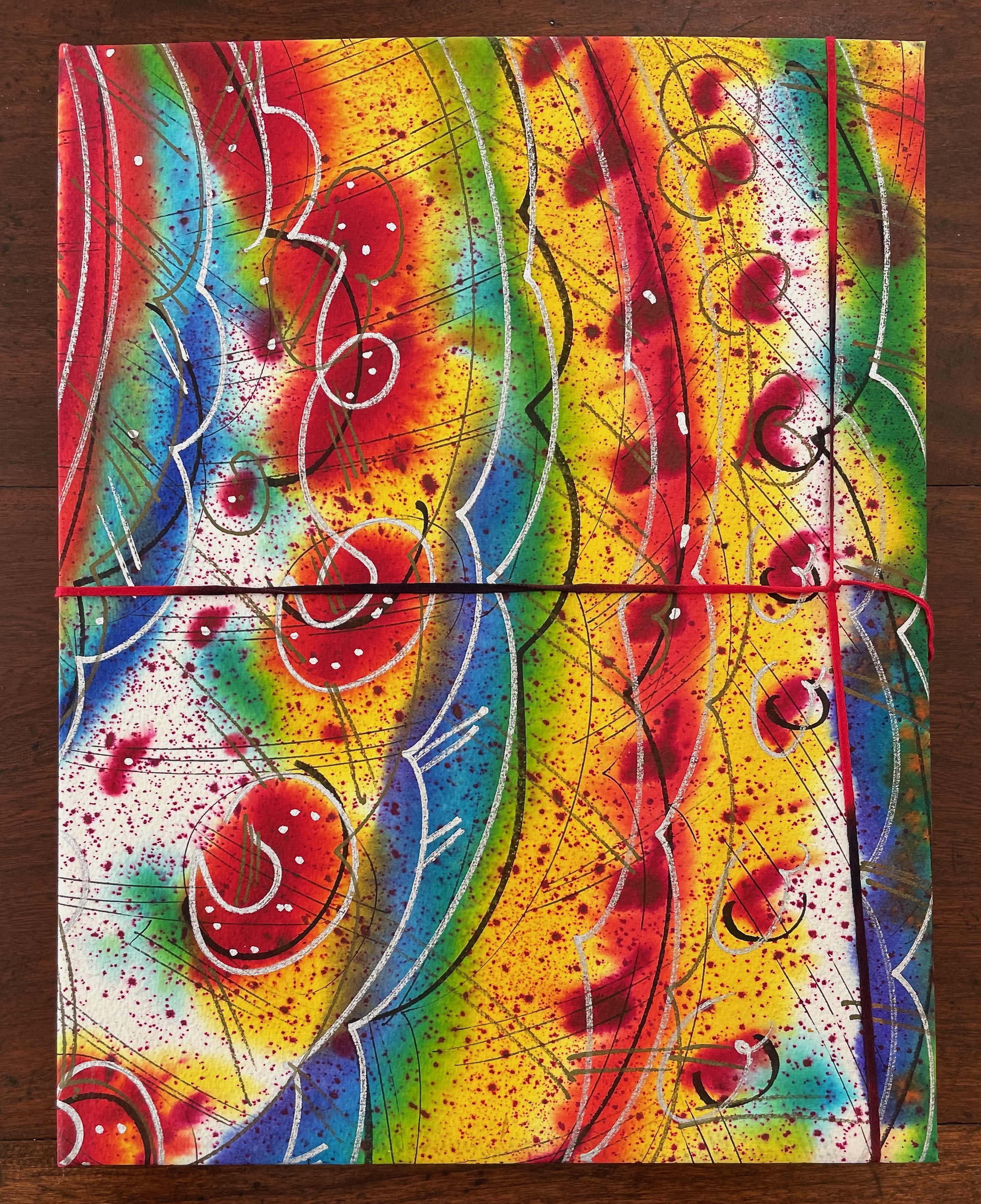 A vibrant abstract artwork featuring swirling patterns and bright colors, including red, yellow, green, blue, and white. The design consists of curved lines and splashes, creating a dynamic and energetic composition.