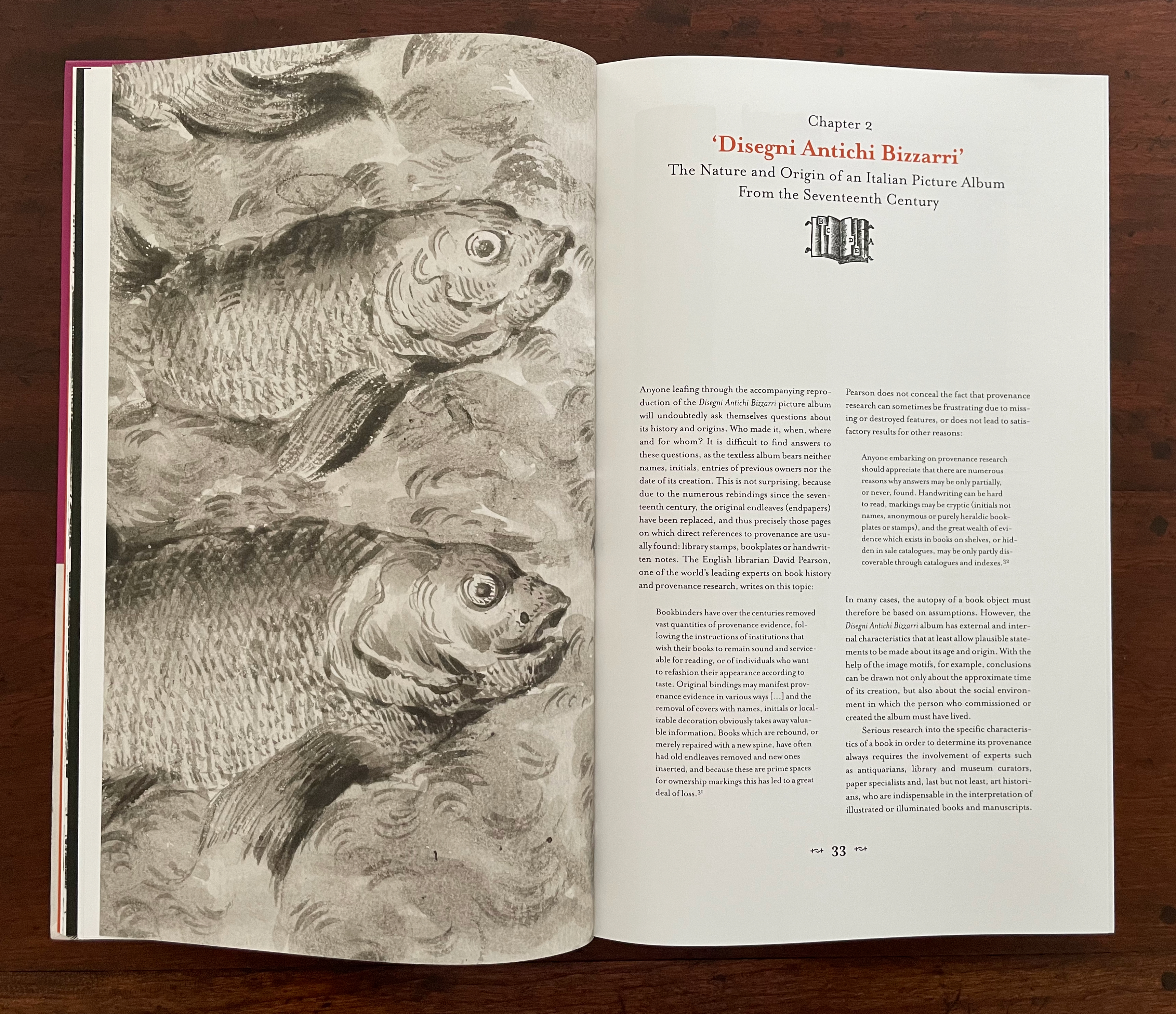 Open book page featuring a detailed illustration of fish on the left side and text about Italian picture albums on the right.