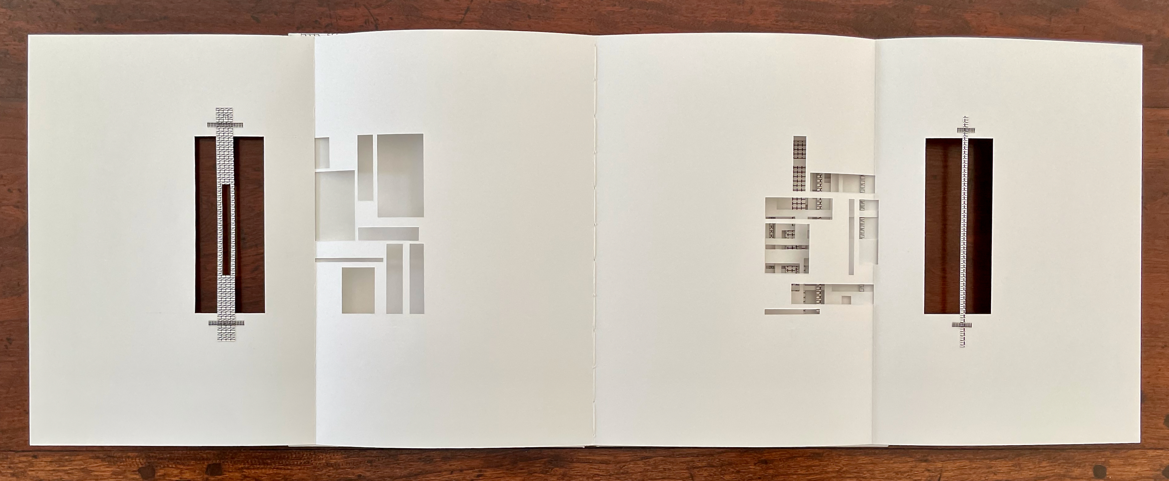An open artist's book featuring intricate cut-out designs on white pages arranged in a layered format, revealing patterns and textures beneath.