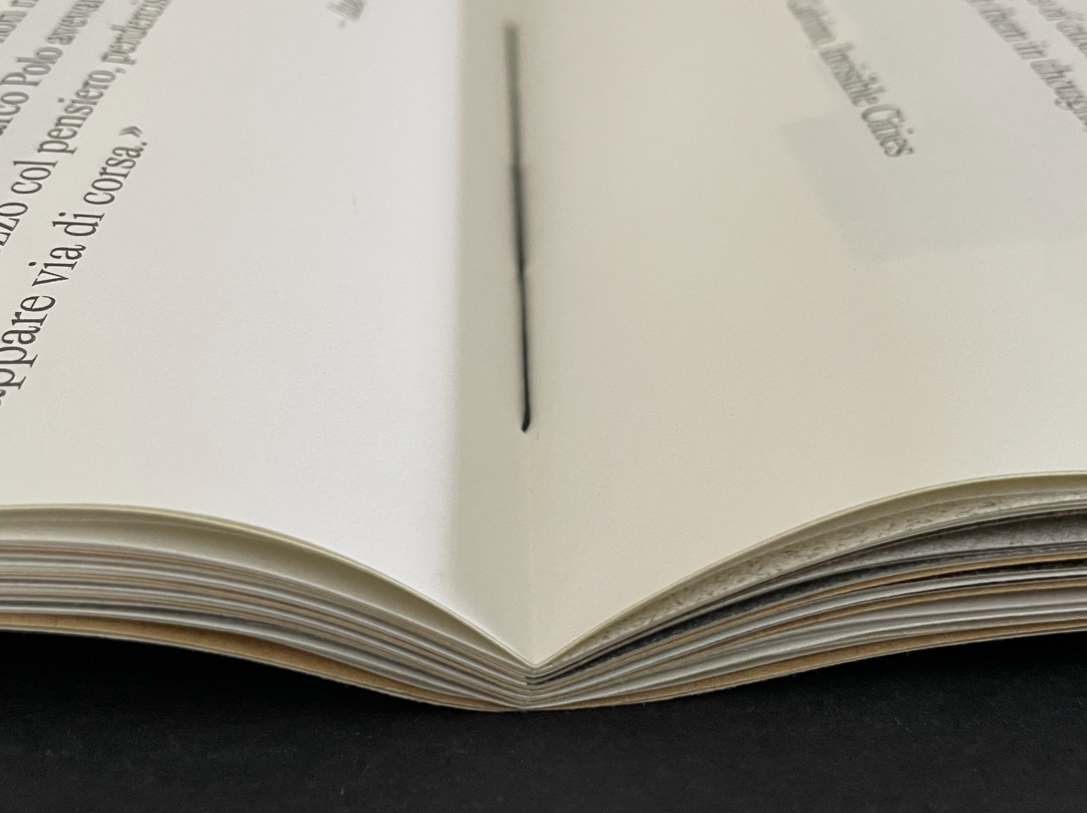 An open book showing the spine and pages, with text partially visible on the left side.