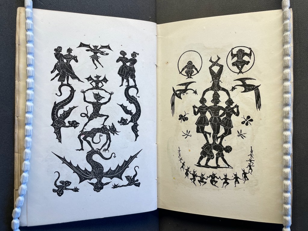 An open book displaying two illustrated pages featuring intricate black and white designs, including figures of dancers, a dragon, and stylized animals.