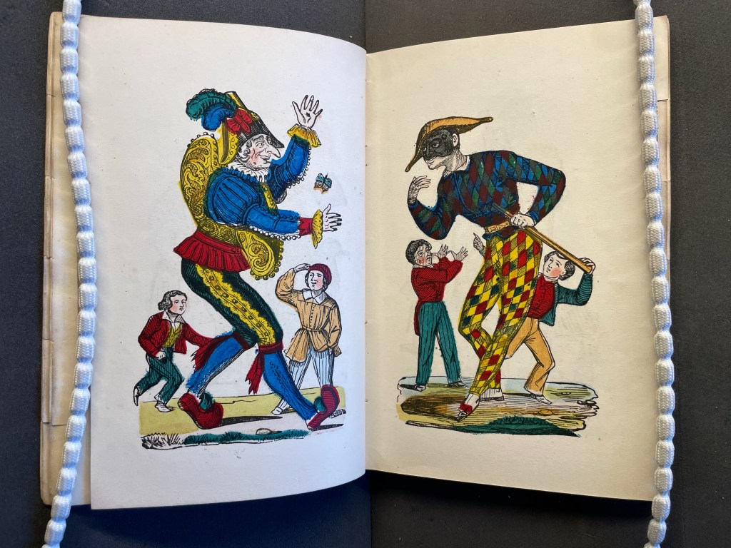 A vintage illustration depicting two colorful figures, one in a jester costume and the other in a harlequin outfit, facing each other. Several smaller characters are nearby, appearing to interact with the larger figures in a playful scene.