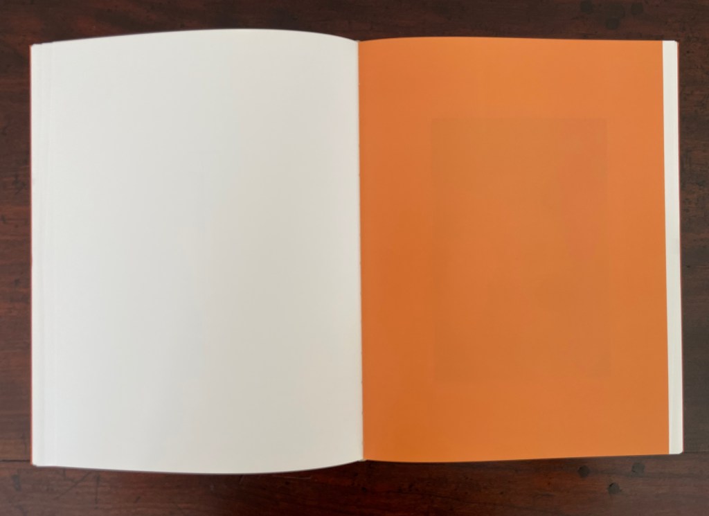 An open book with a blank white left page and an orange right page.