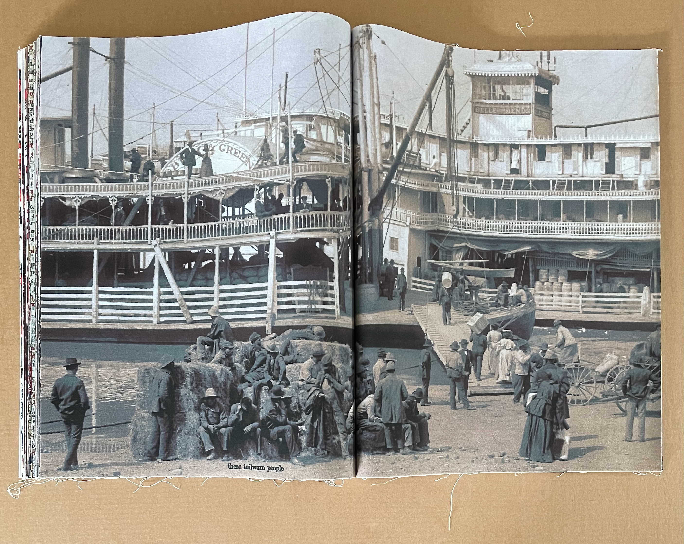 Historical image of a riverboat dock with people engaged in various activities, including loading goods and socializing, captured in a vintage photograph.
