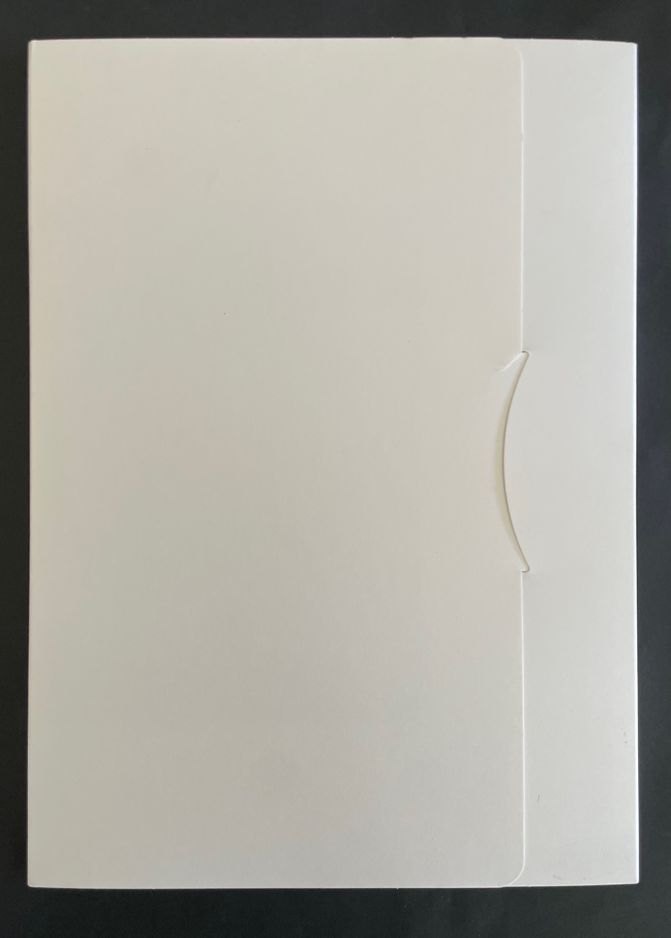 A closed white folder with a curved clasp on a dark background.