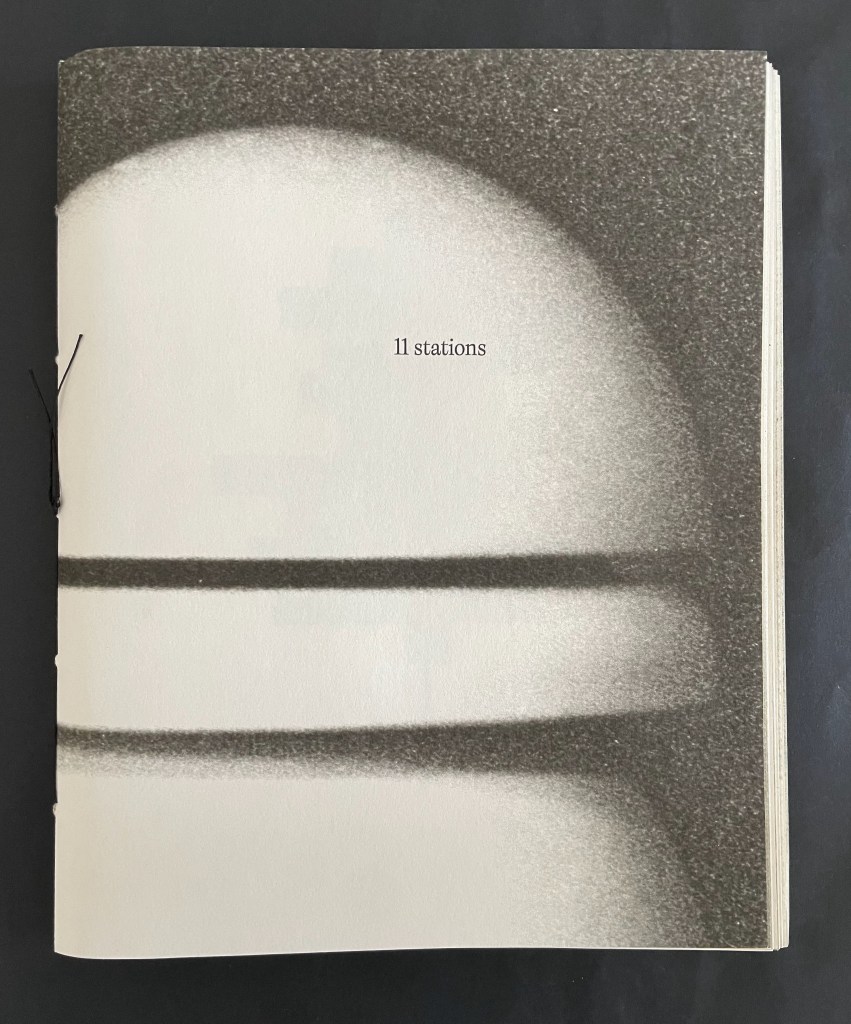 Cover of a book titled '11 Stations' featuring a stylized image resembling a planet with rings, on a black background.